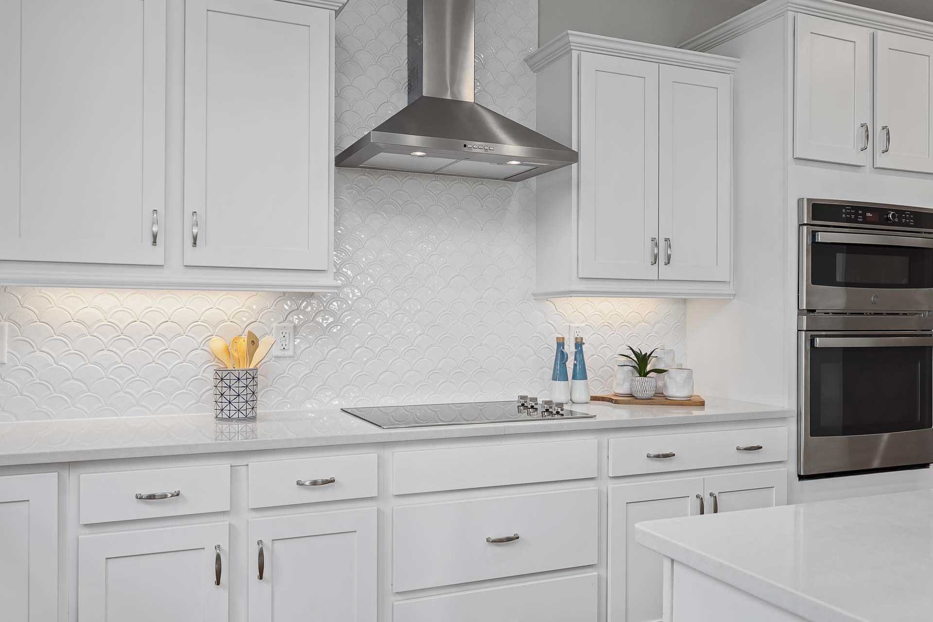 Modern white shaker kitchen in Highland Forest, Fuquay-Varina NC featuring stainless steel appliances, subway tile backsplash