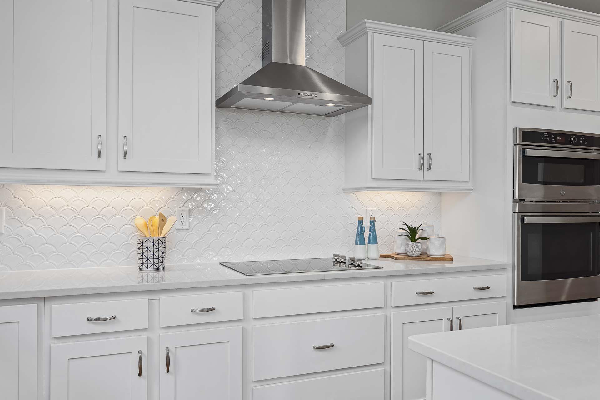Modern white shaker kitchen in Highland Forest, Fuquay-Varina NC featuring stainless steel appliances, subway tile backsplash