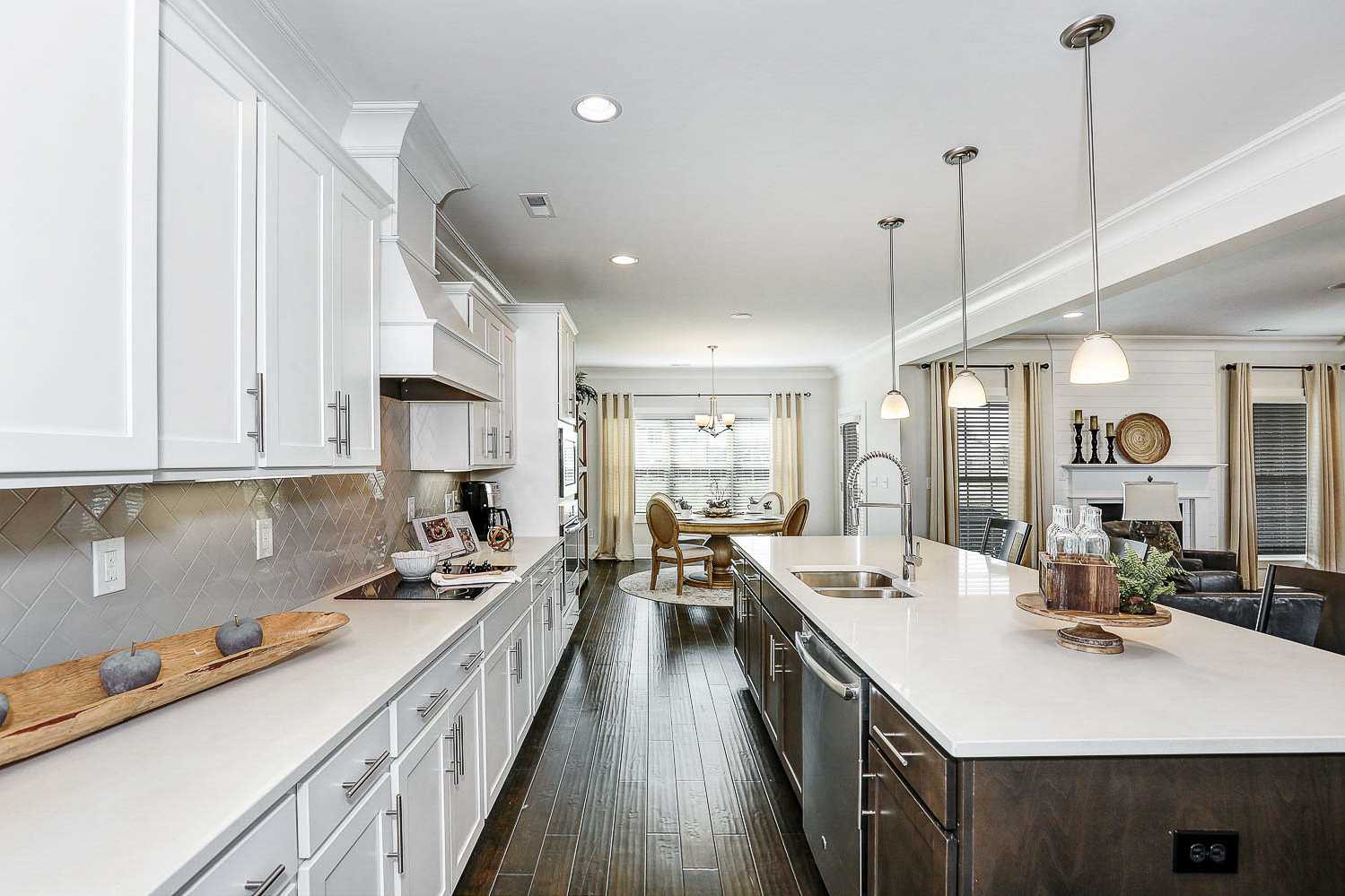 Open-concept kitchen in The Finleigh by Davidson Homes featuring white shaker cabinets, quartz island, subway tile backsplash, and dining nook