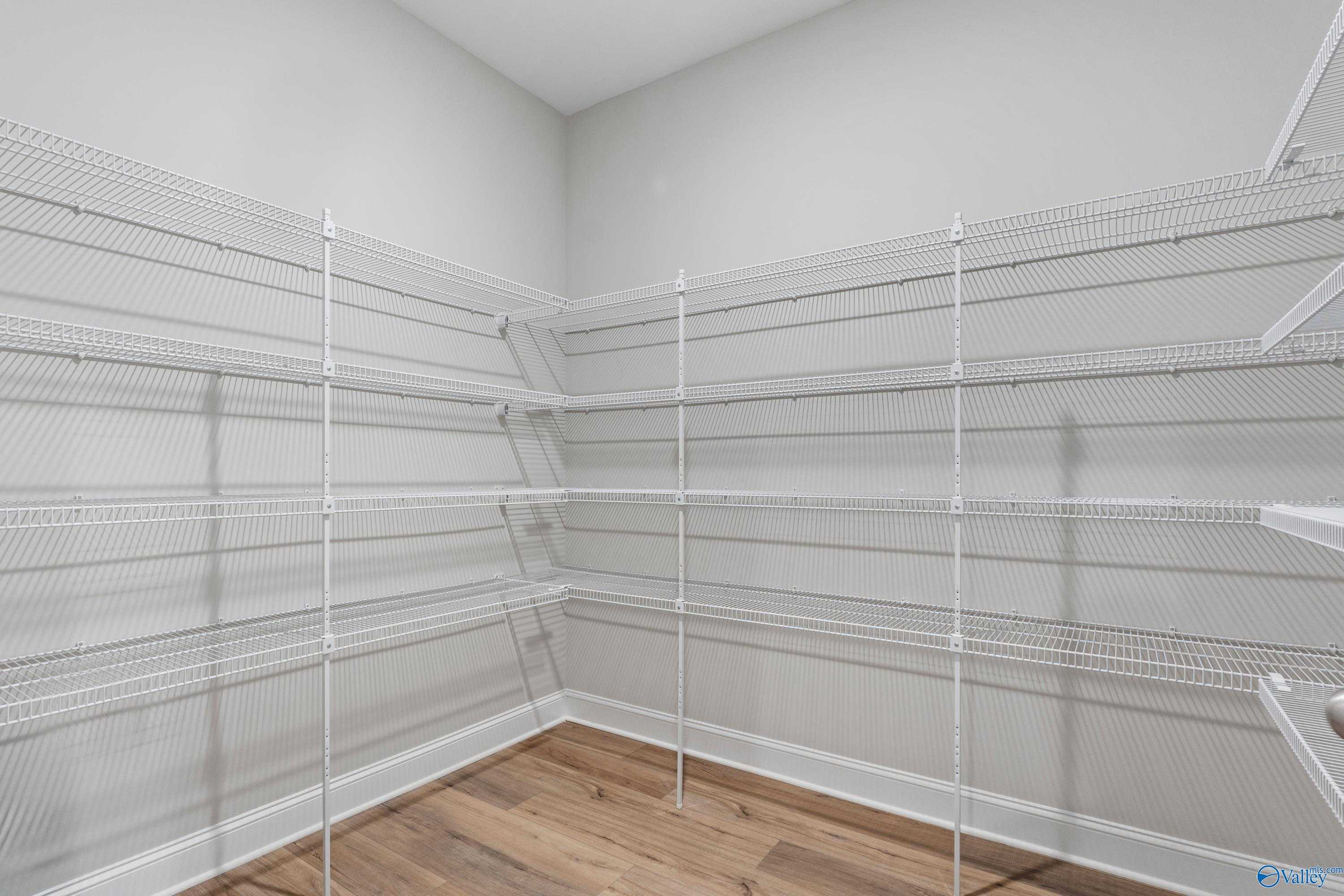 Spacious walk-in closet with white wire shelving on three walls in Davidson Homes The Finleigh, Meridianville, Alabama