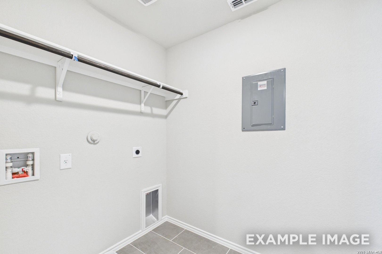 Utility room with laundry hookups and shelving in The Charlotte B floor plan at Cedar Heights, San Antonio, Texas.