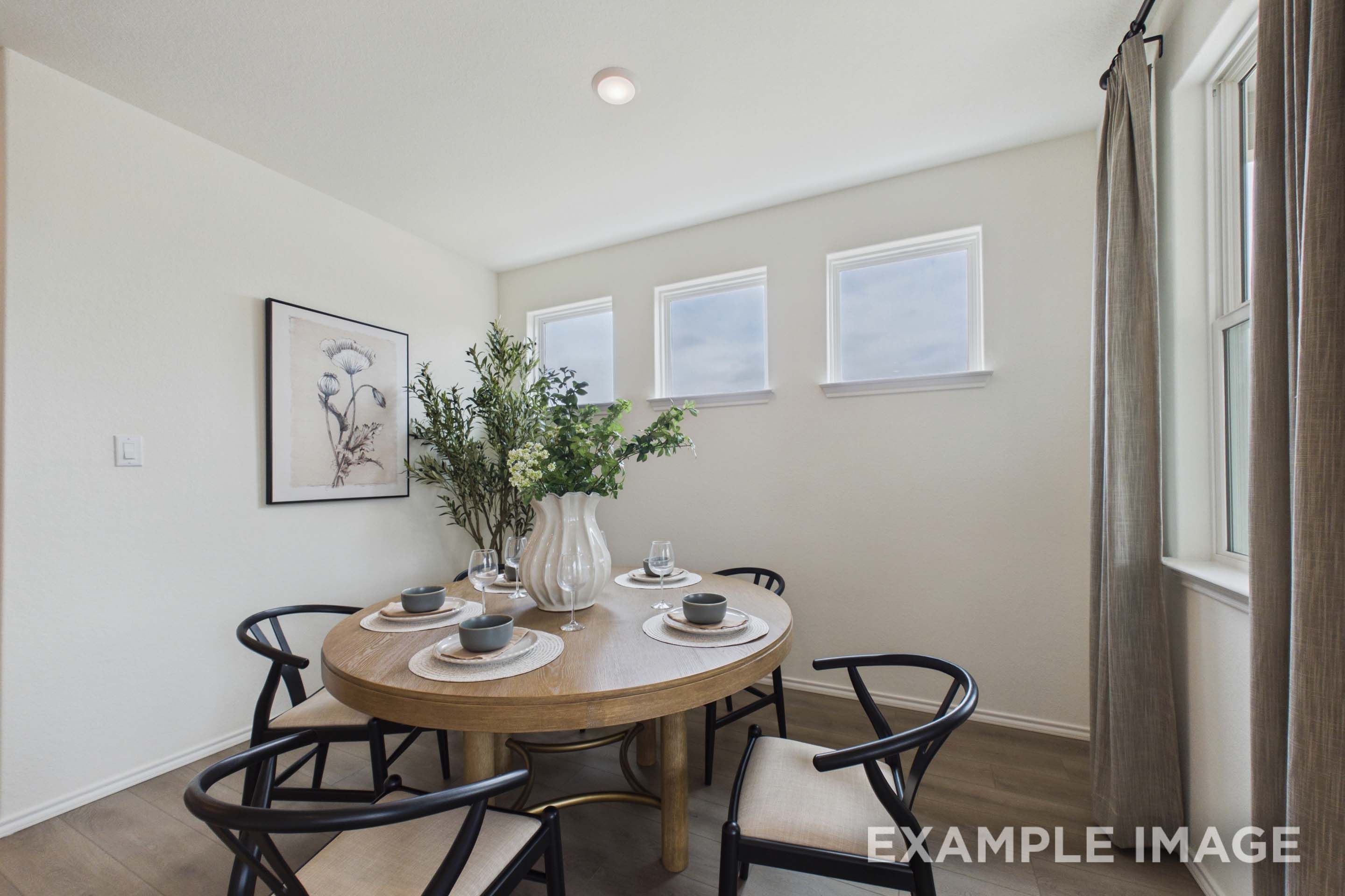 Bright dining area in The Laurel G floor plan featuring a round wooden table, modern chairs, and stylish decor.