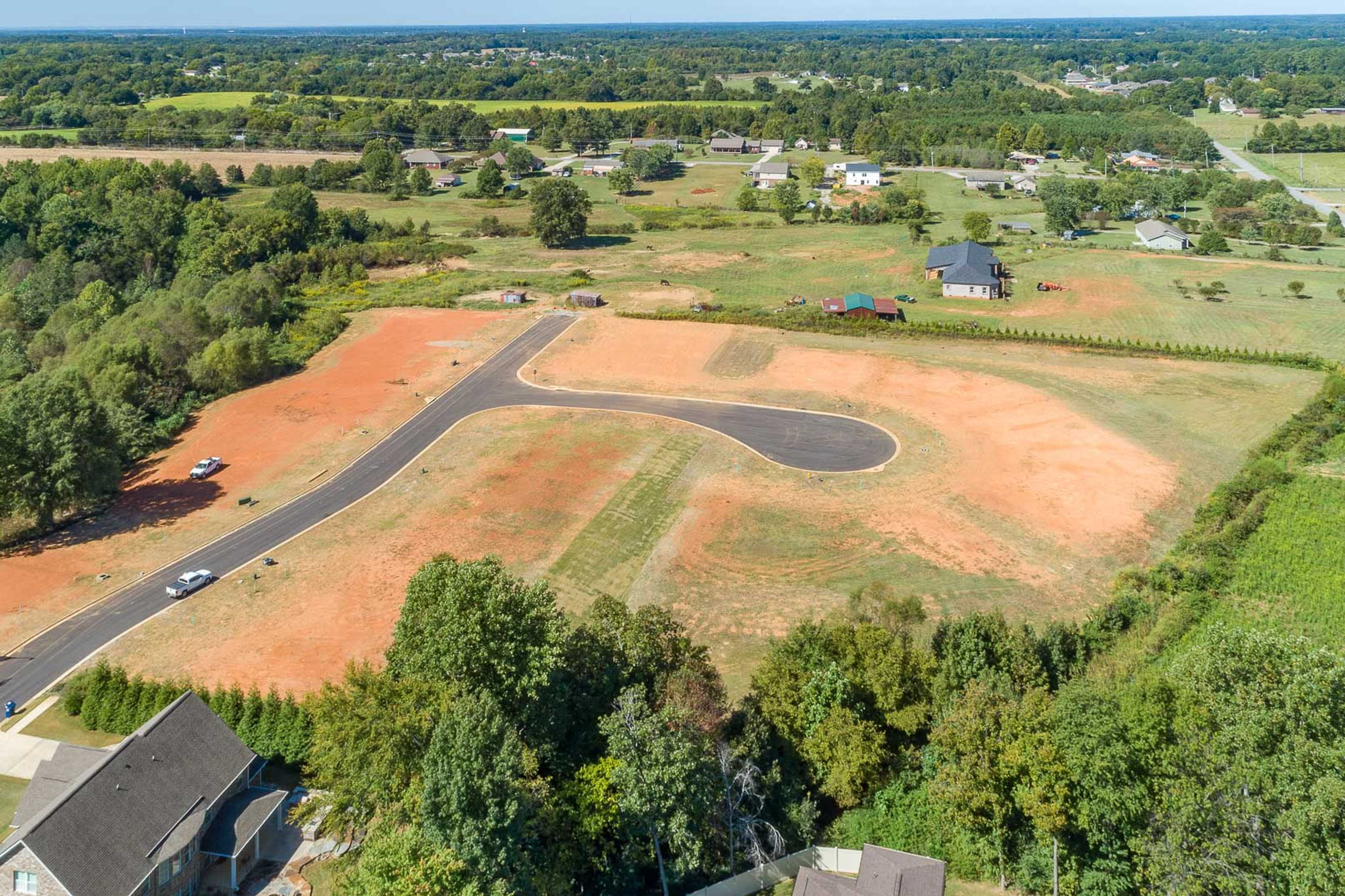 Aerial view of developing lots at Little Burwell Estates in Harvest Alabama with curved paved roads and surrounding greenery