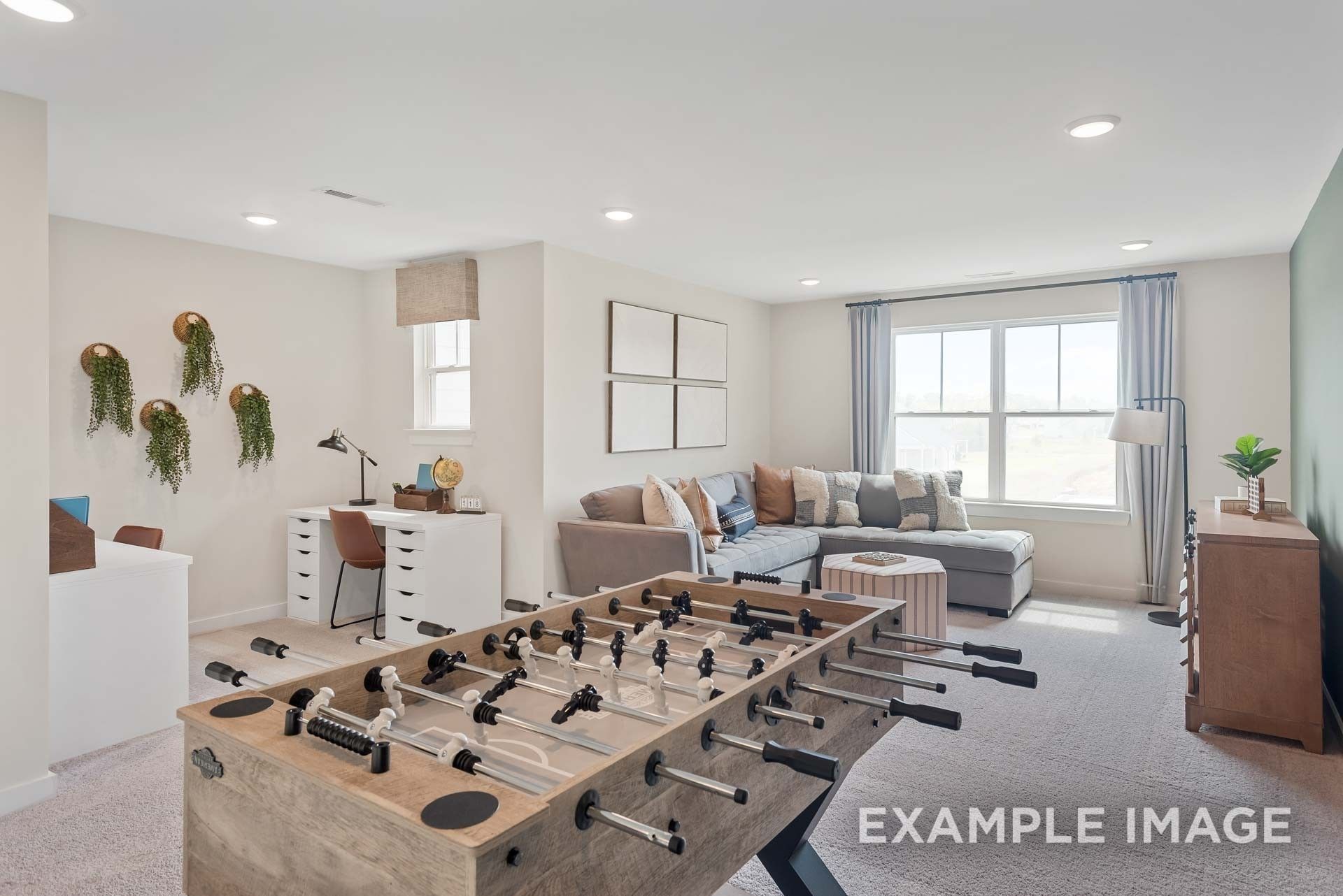 Fun game room featuring foosball table, gray sectional sofa, and desk in 5-bedroom Davidson Homes The Ridgeport C, Gallatin, TN
