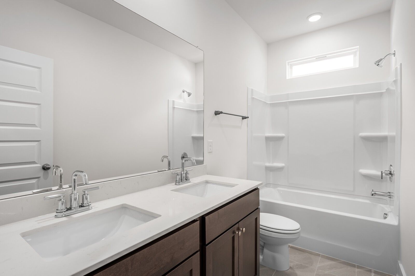 Modern bathroom with dual vanity, quartz countertops, and tub-shower combo in The Cottonwood E, Woods Crossing, Gallatin, TN.
