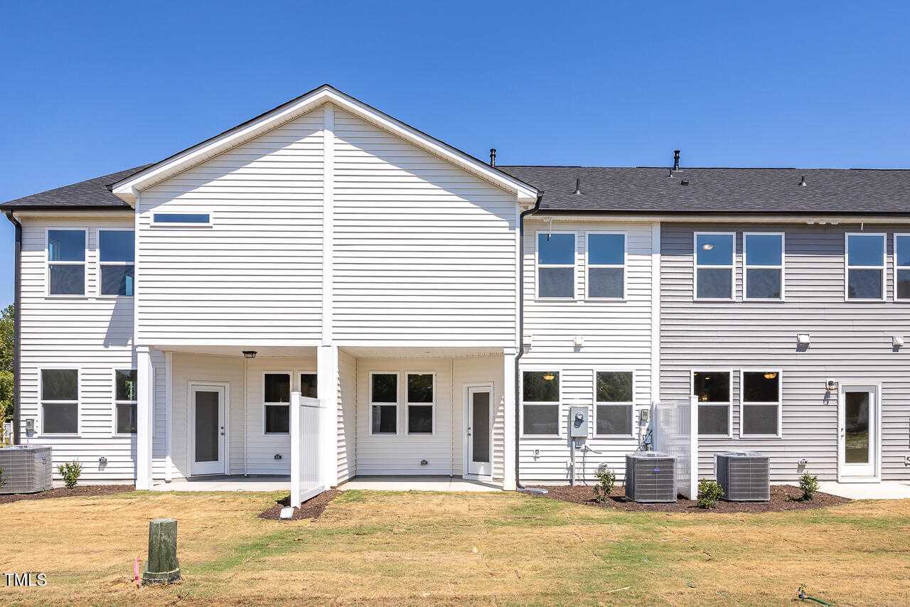 Rear view of modern 2-story The Graham townhome by Davidson Homes in Springvale, Fuquay-Varina, NC, with covered patio and partial fencing