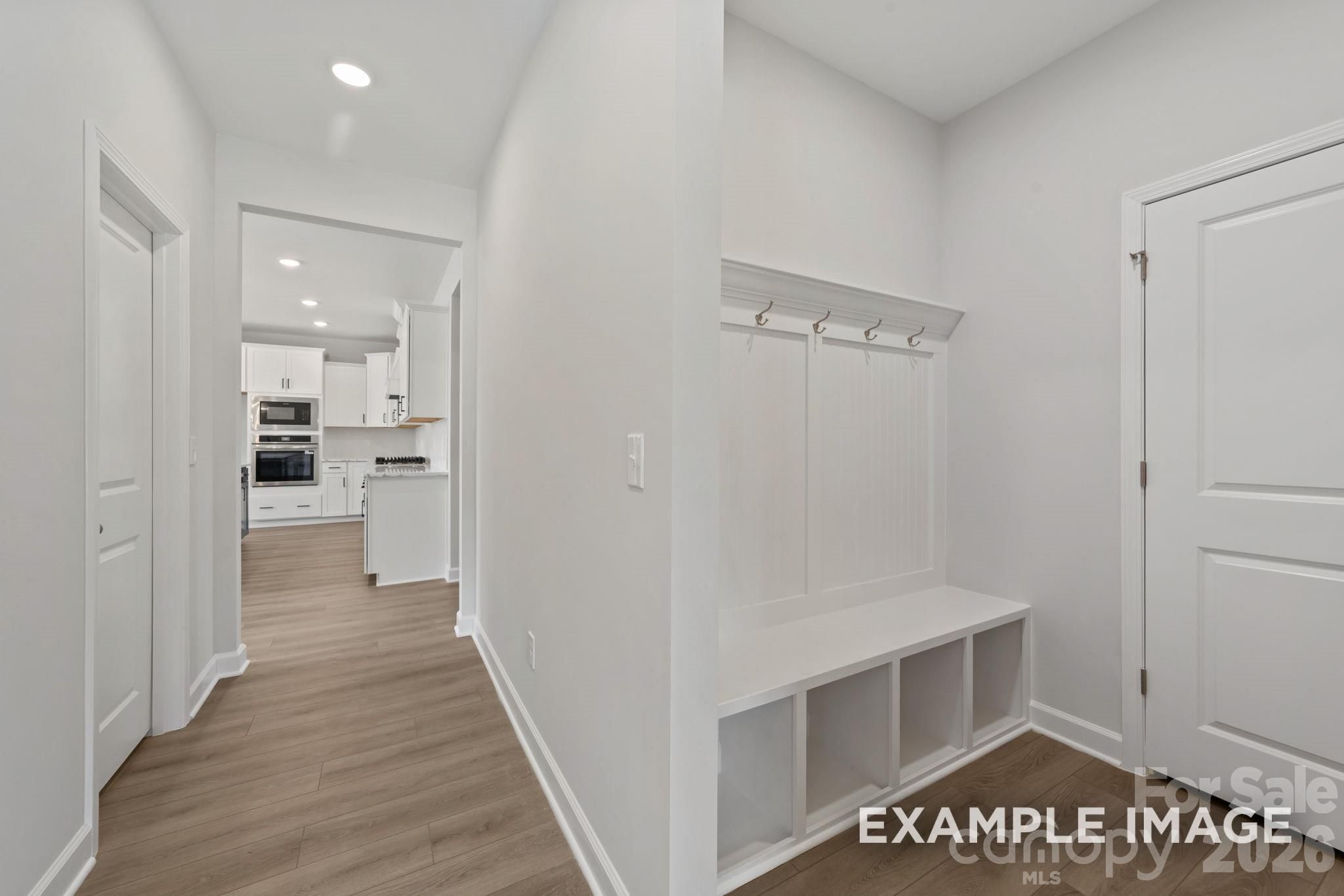 Built-in mudroom bench with coat hooks in the Magnolia B floor plan at Windgate, Mooresville, North Carolina.