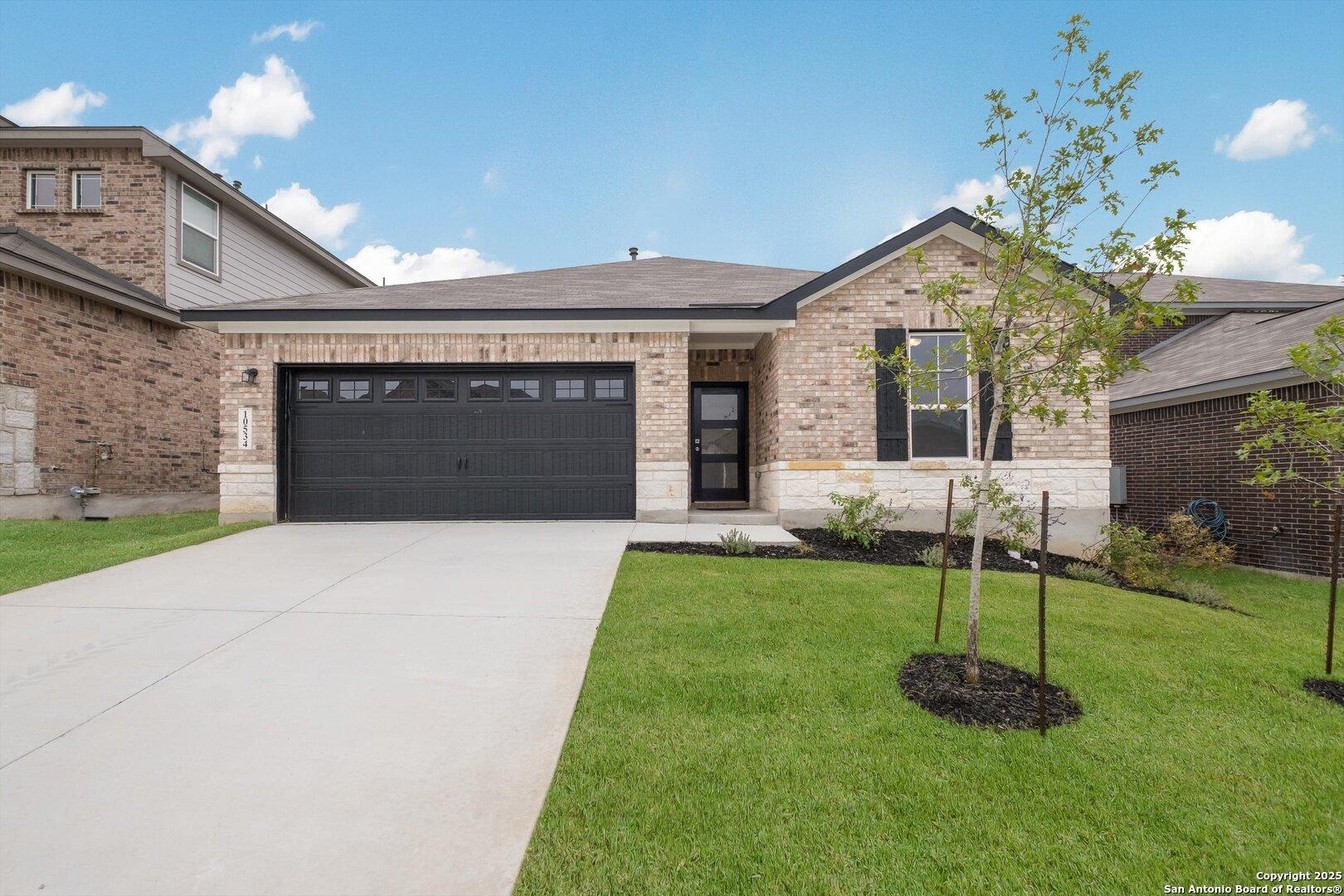 Modern 1-story brick home with 2-car garage, driveway, and landscaped yard in Bricewood, San Antonio, Texas by Davidson Homes The Asheville K