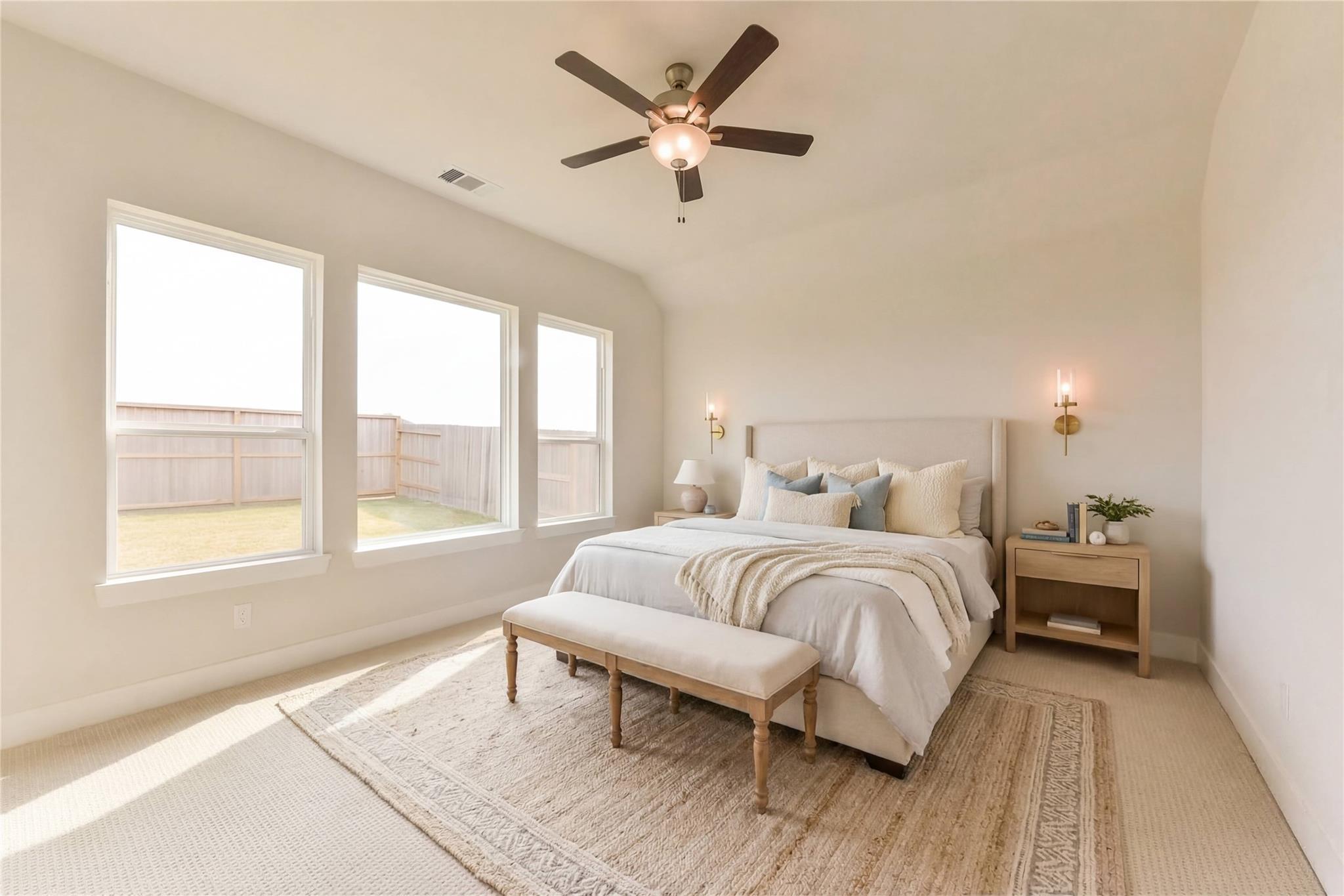 Bright master bedroom with king bed, beige walls, ceiling fan, and backyard views in Davidson Homes The Edward A, Lago Mar
