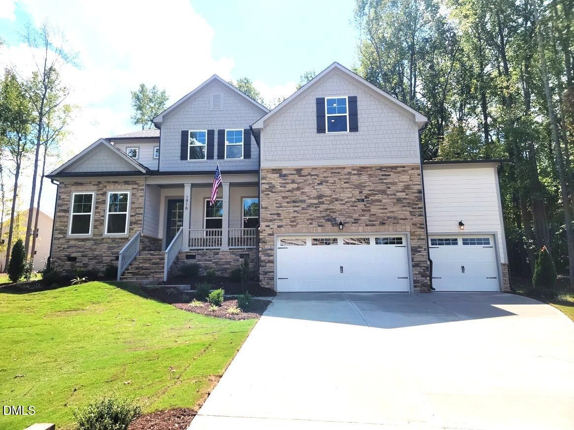 Front exterior of 2-story Davidson Homes Crawford D plan with stone accents, 3-car garage, and covered porch in Rockport, Wake Forest, NC