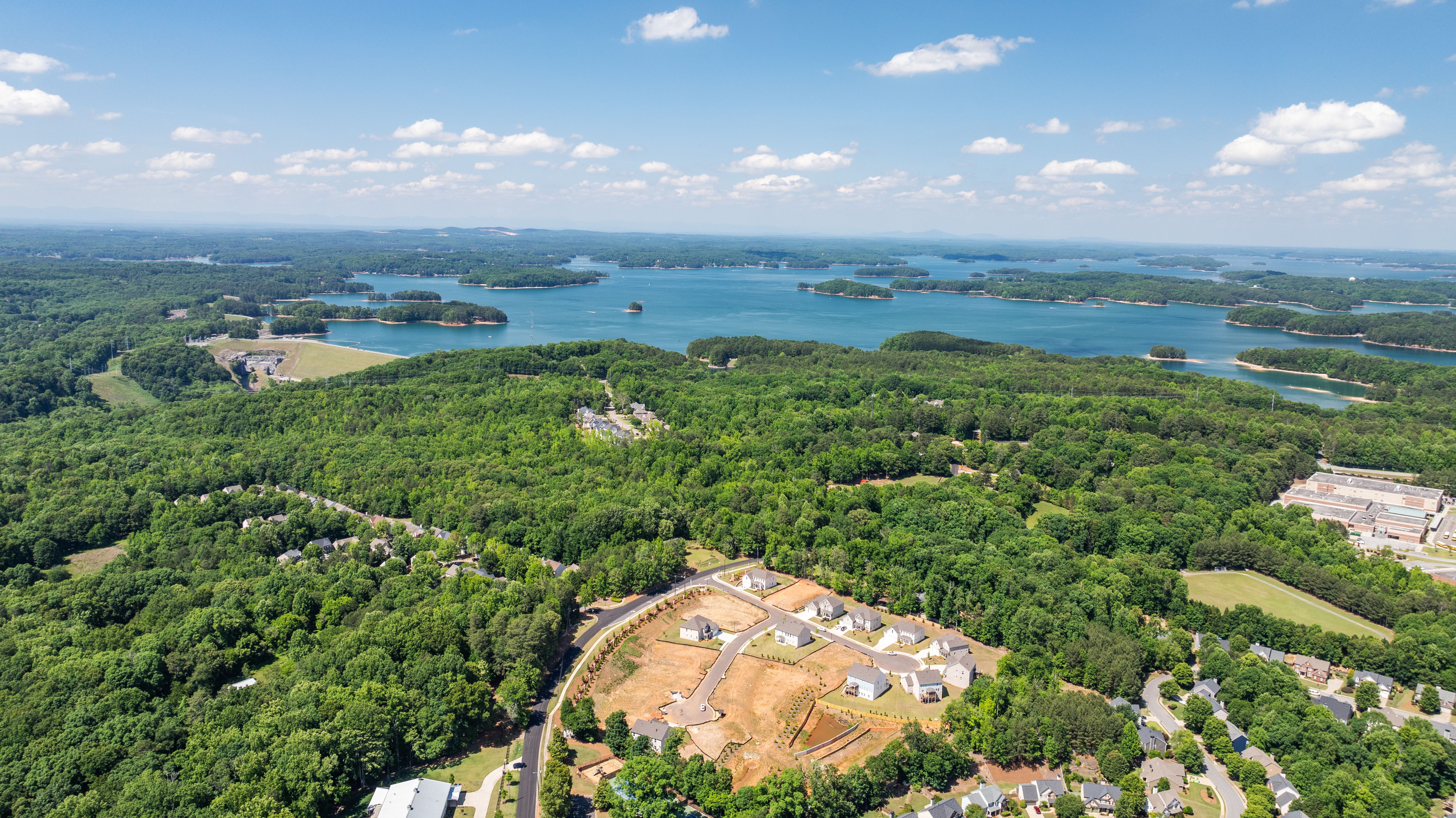 Aerial view of Melody Lakeside Estates by Davidson Homes in Buford, Georgia, featuring wooded lots and lakefront views.