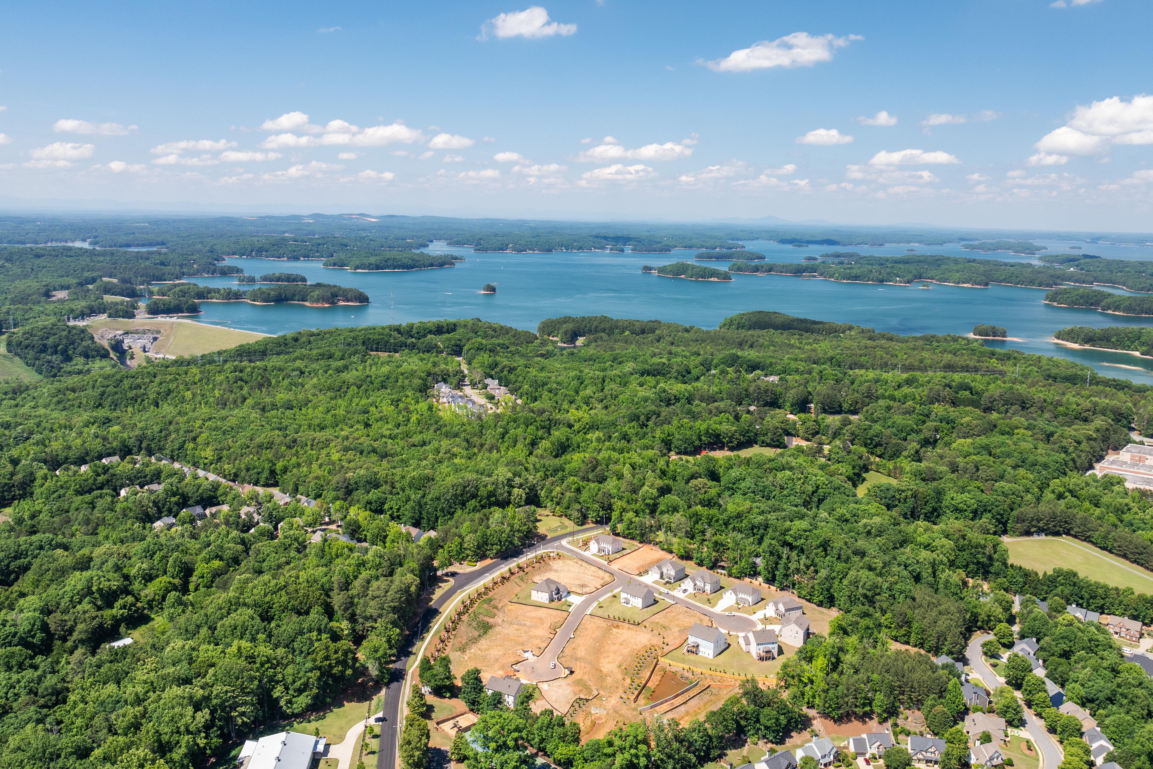 Aerial view of Melody Lakeside Estates by Davidson Homes in Buford, Georgia, featuring wooded lots and lakefront views.
