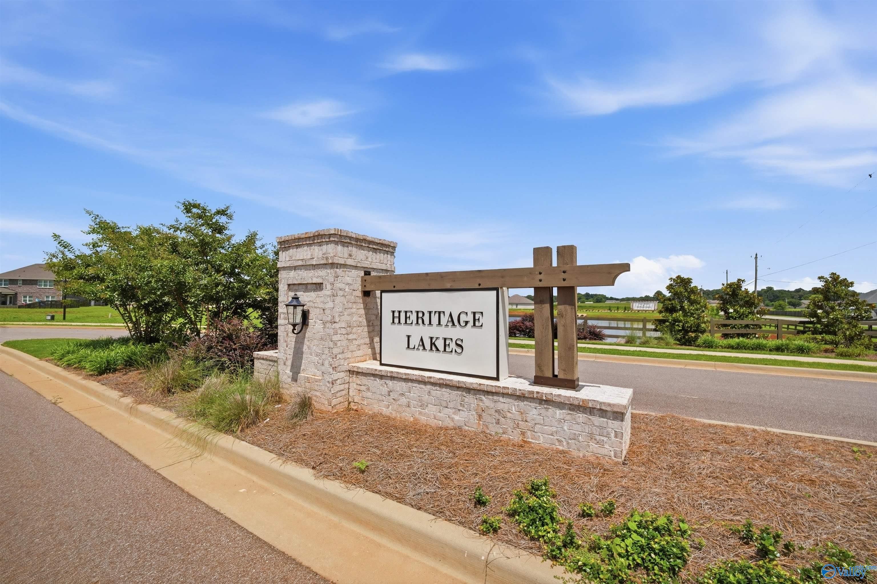 Heritage Lakes neighborhood entrance sign featuring brick masonry and wooden accents in New Market, Alabama.