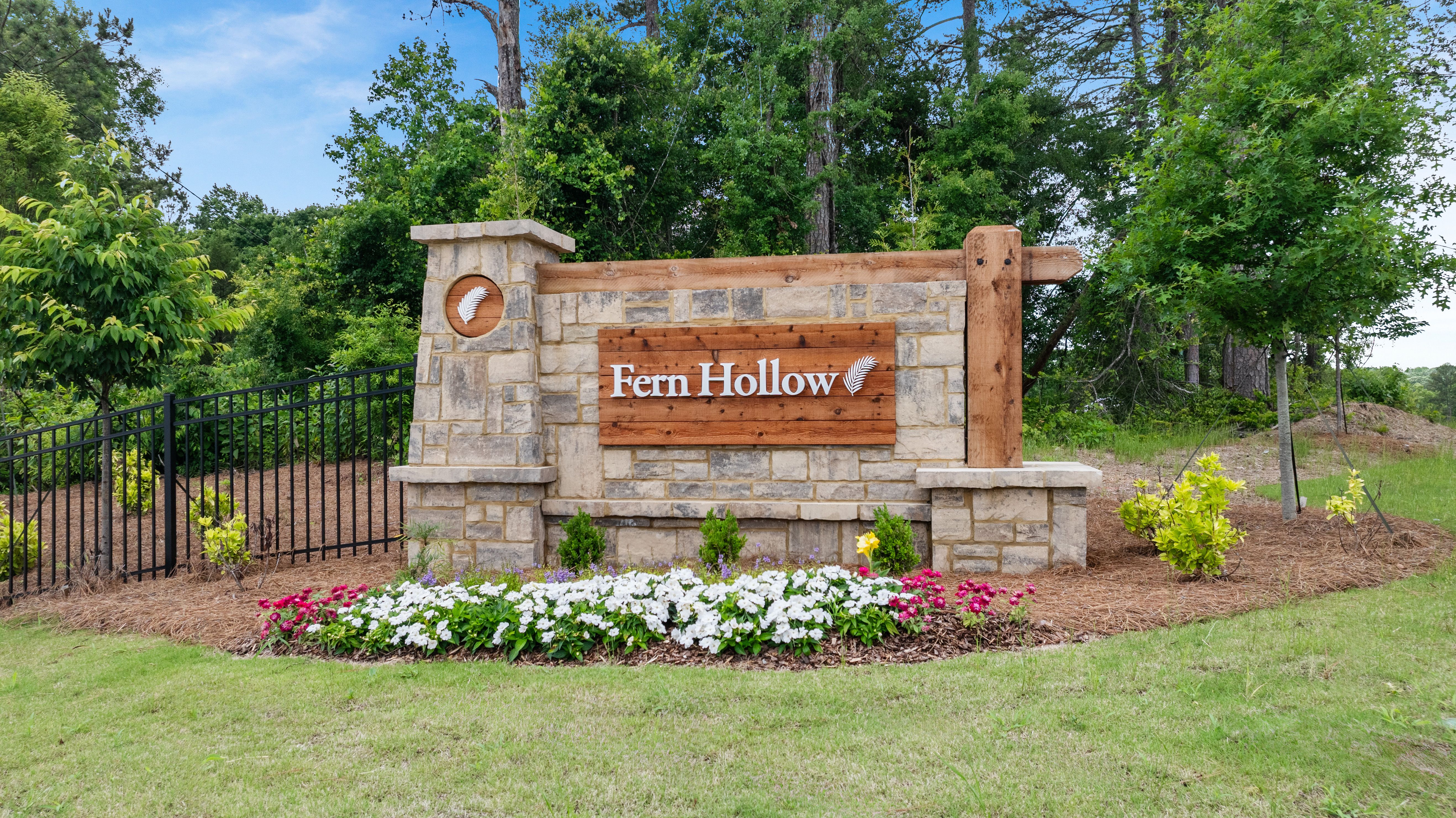 Stone and wood community entrance sign for Fern Hollow by Davidson Homes in Buford, Georgia, surrounded by landscaping.