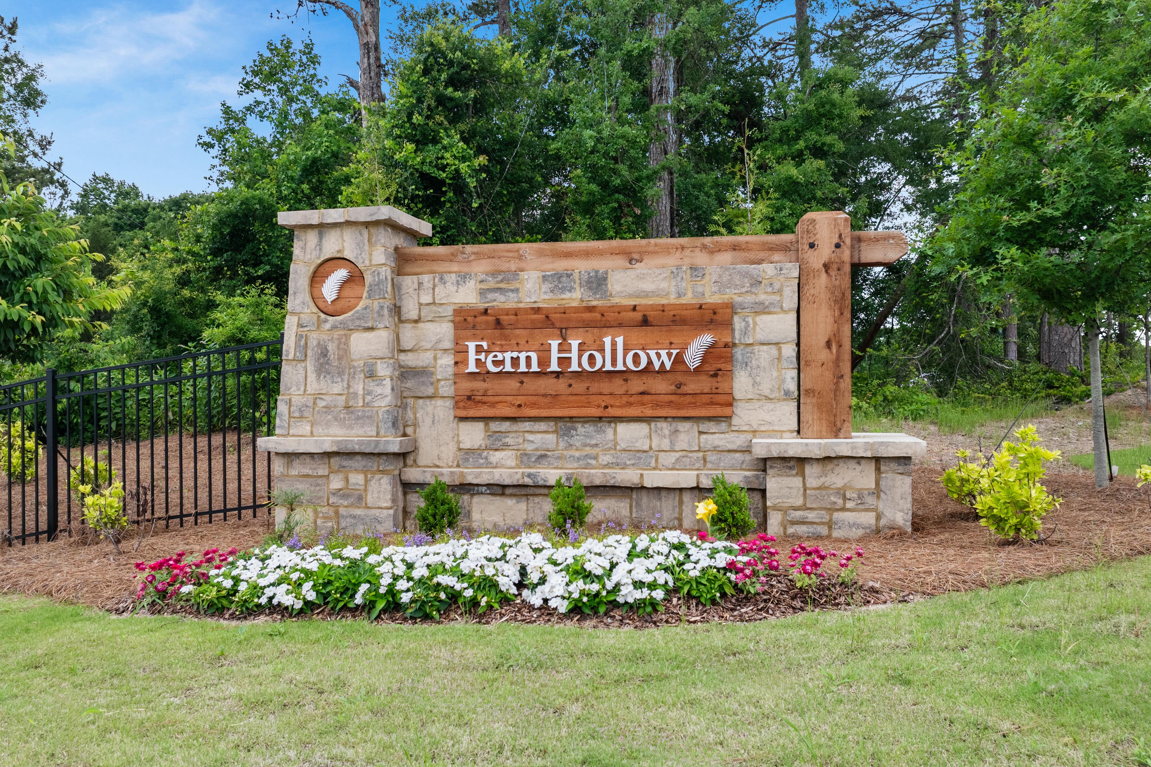 Stone and wood community entrance sign for Fern Hollow by Davidson Homes in Buford, Georgia, surrounded by landscaping.