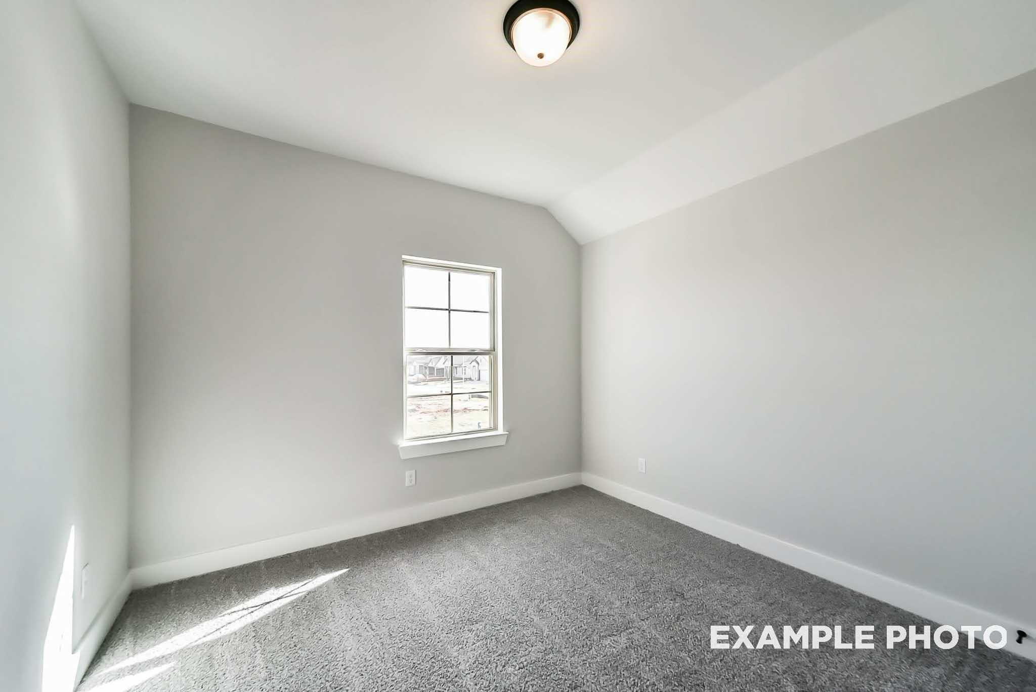 Bright secondary bedroom featuring gray walls, plush carpet, large window with natural light in Davidson Homes The Philip C, Rosharon, Texas