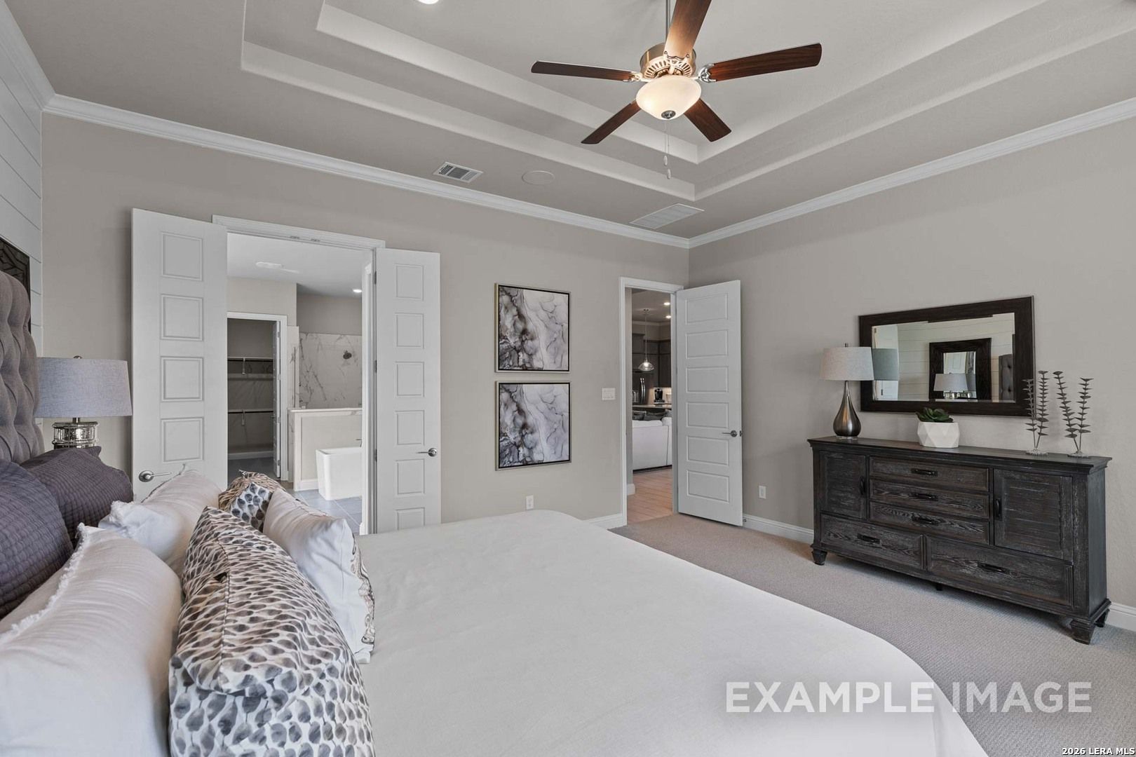 Spacious primary bedroom with tray ceiling in The Garner C floor plan at The Reserve at Potranco Oaks, Castroville, Texas.