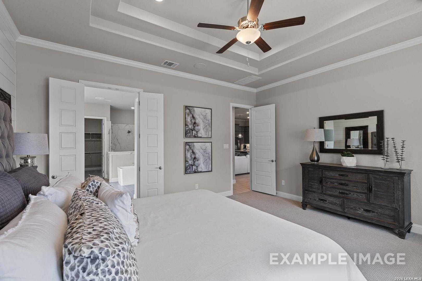 Spacious primary bedroom with tray ceiling in The Garner C floor plan at The Reserve at Potranco Oaks, Castroville, Texas.