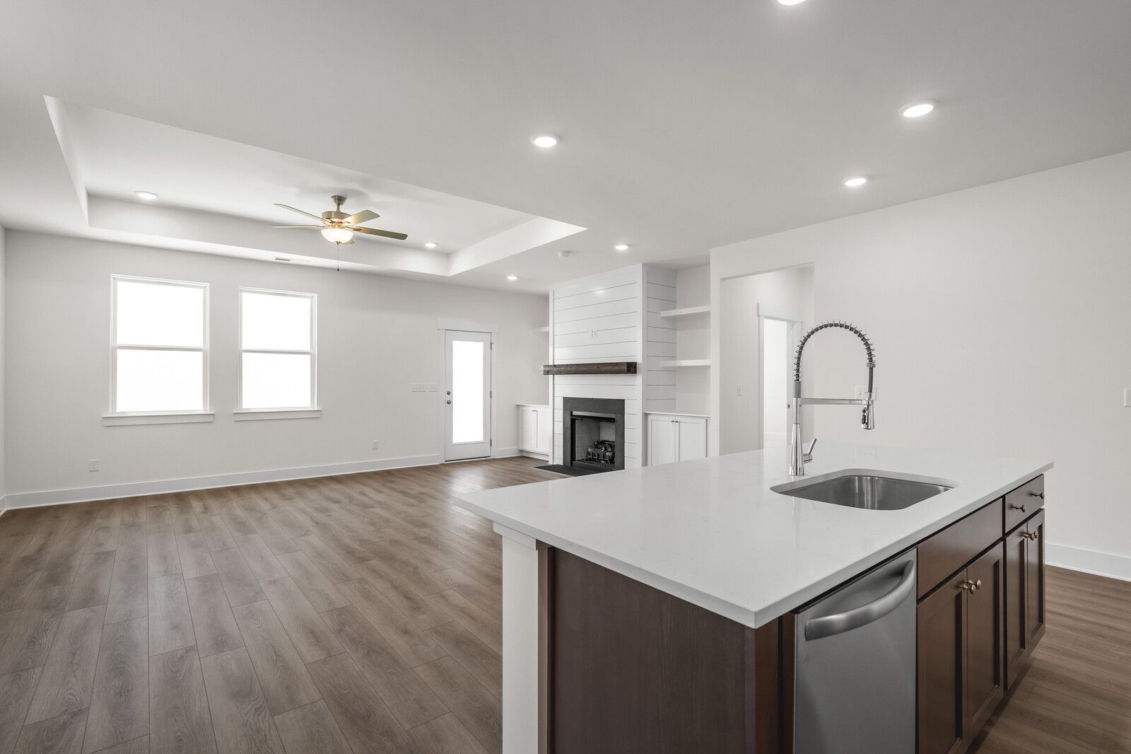 Open-concept living space in The Cottonwood featuring a modern kitchen island, fireplace, and spacious floor plan.