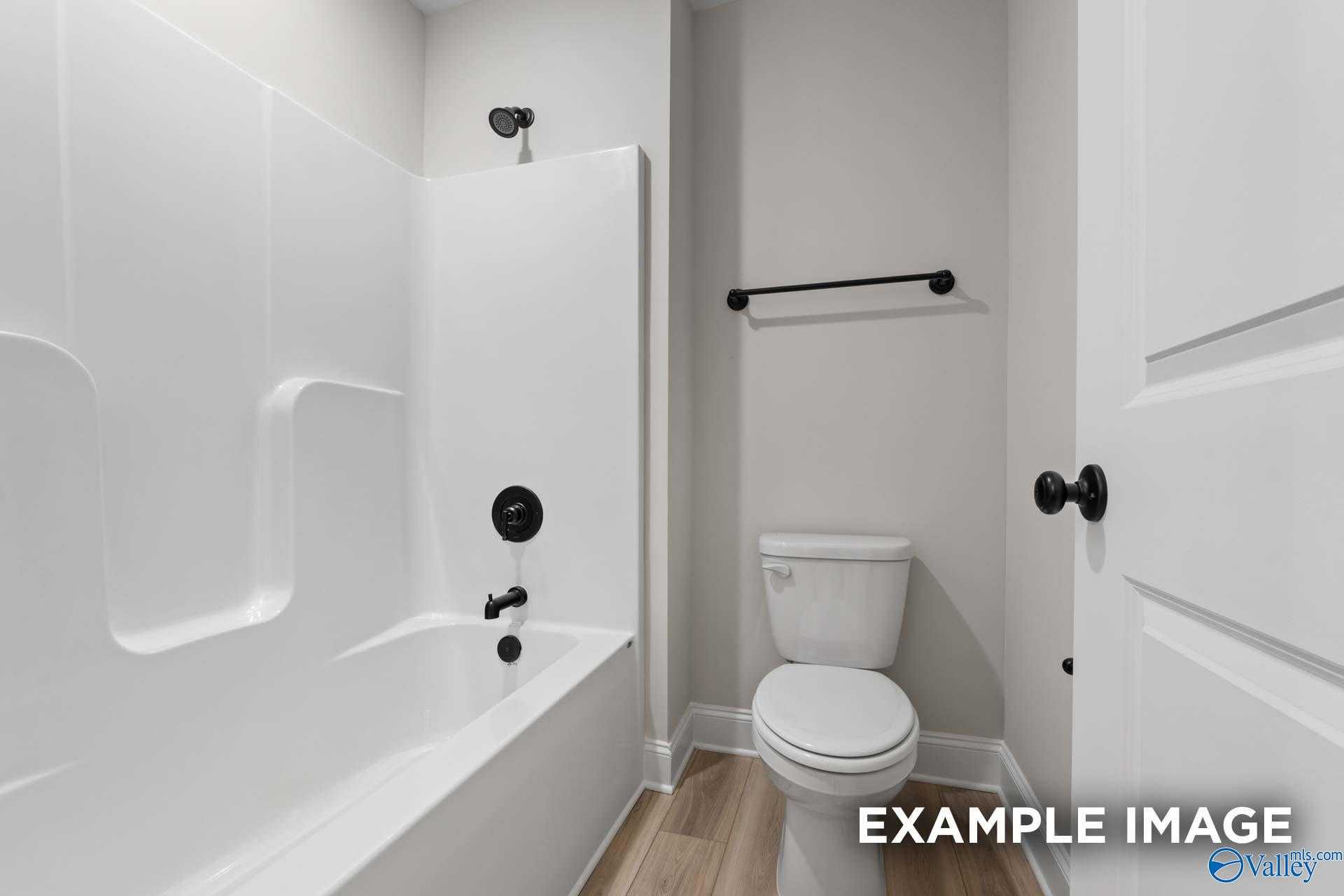 Modern bathroom featuring white bathtub, walk-in shower, and toilet in The Camden D by Davidson Homes, Pavilion, Huntsville