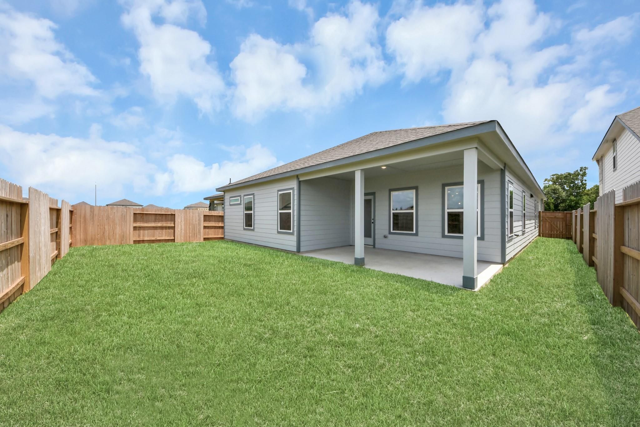 Covered back patio and fenced backyard of The Sorrento E floor plan by Davidson Homes in Sundance Cove, Crosby, Texas.