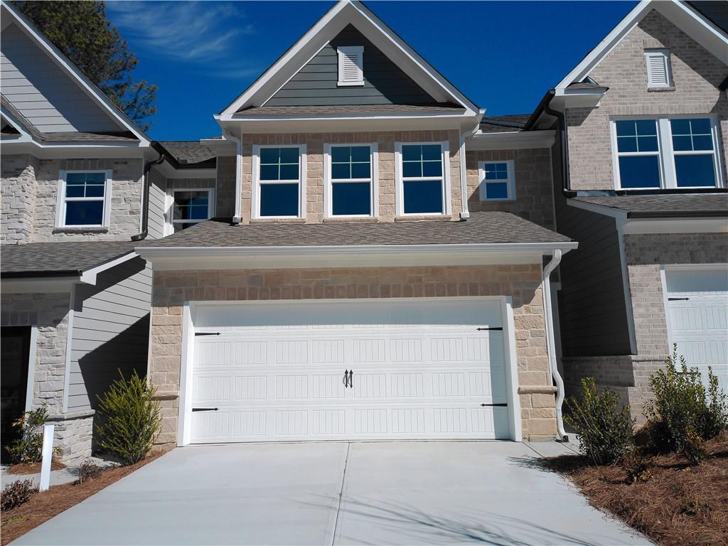 Modern 2-story Marion C home exterior featuring 2-car garage, stone accents, and driveway in Lake Shore, Winder, Georgia by Davidson Homes