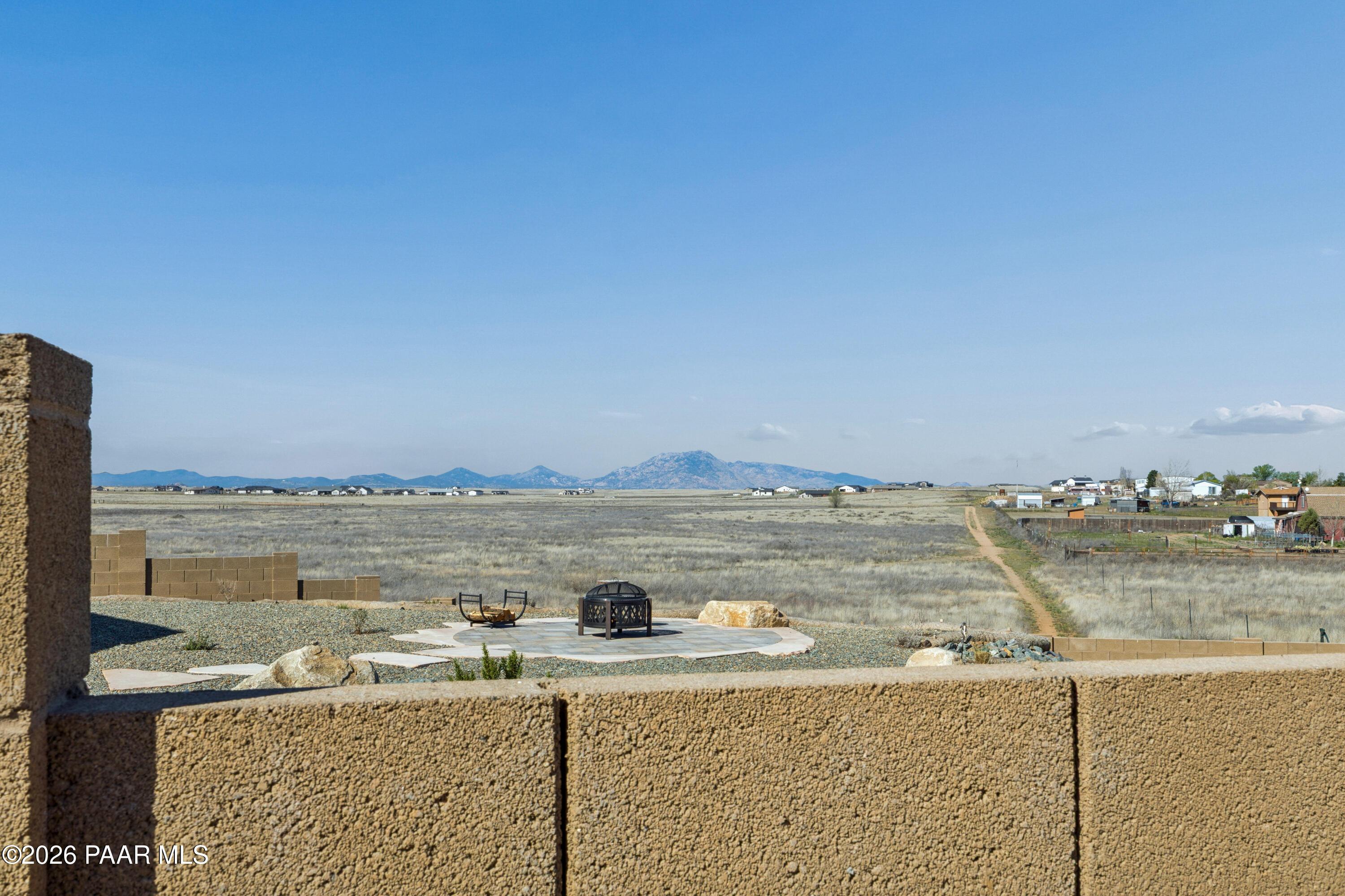 Outdoor fire pit in rocky backyard with desert mountain views, Davidson Homes The Harmony A, Pronghorn Ranch, Prescott Valley, AZ