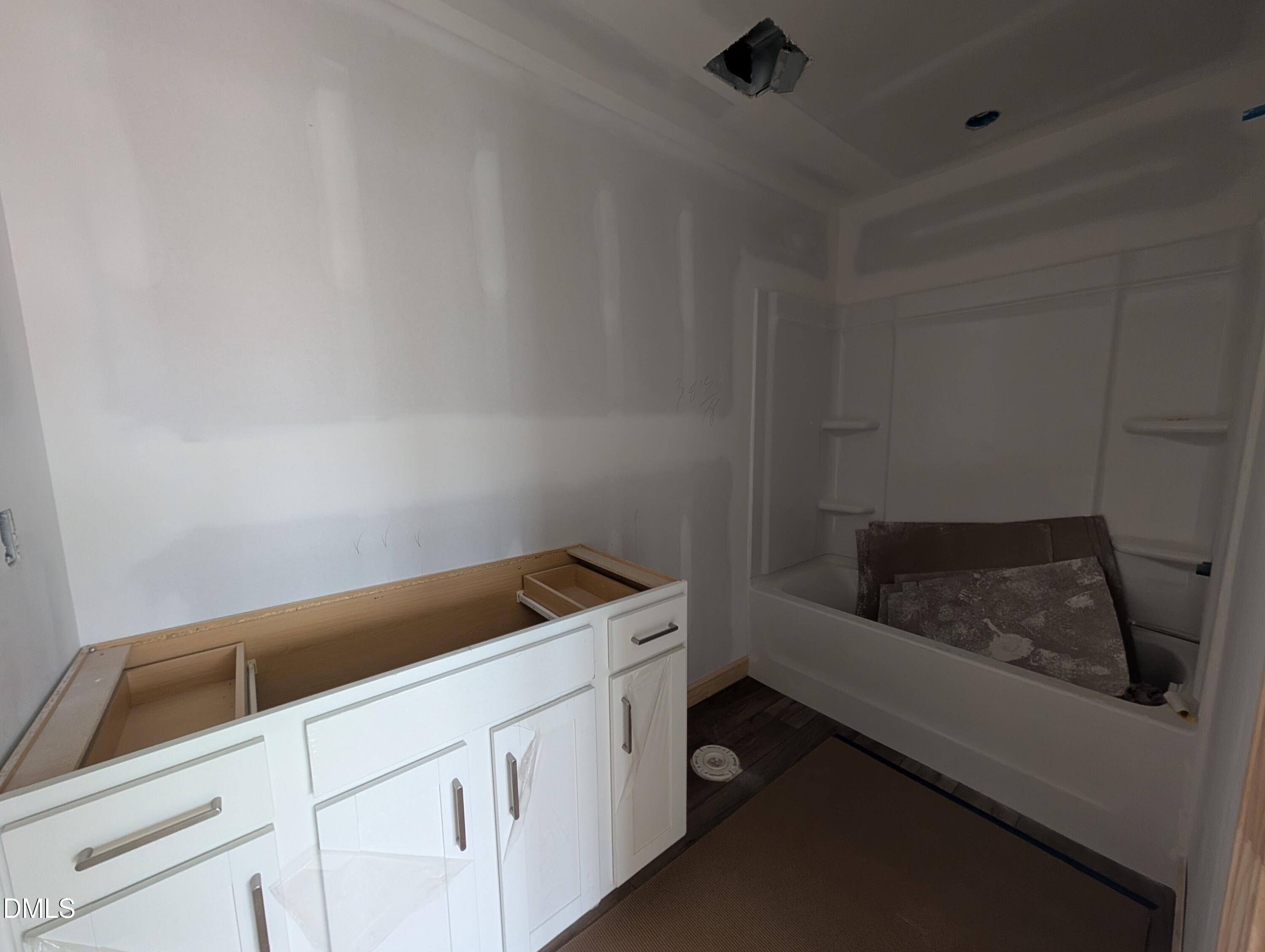 Bathroom under construction with white vanity cabinet and tub-shower combo in The Beech floor plan home by Davidson Homes, Wendell Ridge, NC