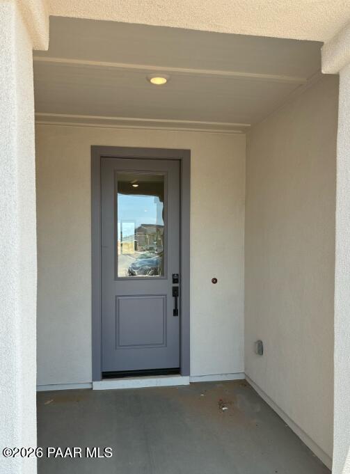 Covered front entryway with modern grey door at The Durango II G home in South Ranch, Prescott, Arizona.
