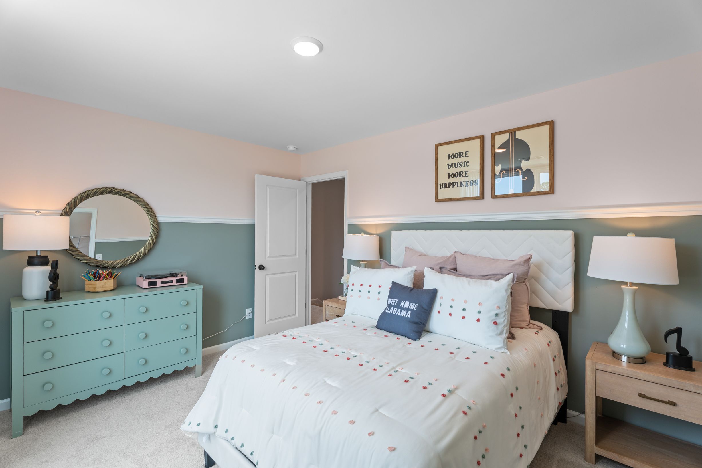 Cozy bedroom with sage green wainscoting and pink walls at Links Crossing in Auburn, Alabama by Davidson Homes.
