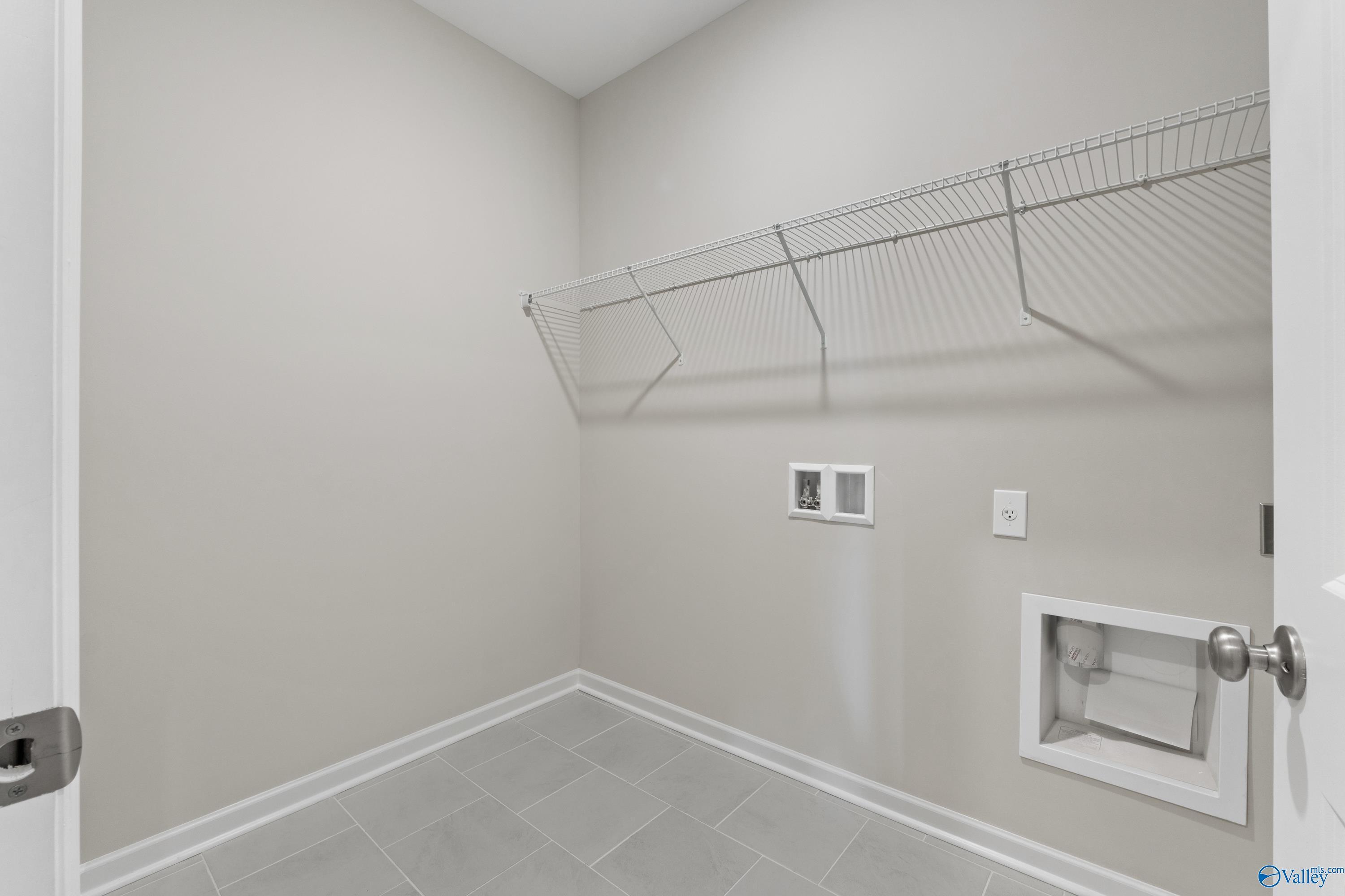 Spacious laundry room with wire shelving, washer-dryer hookups, utility sink in Davidson Homes The Luna, Hazel Green, Alabama