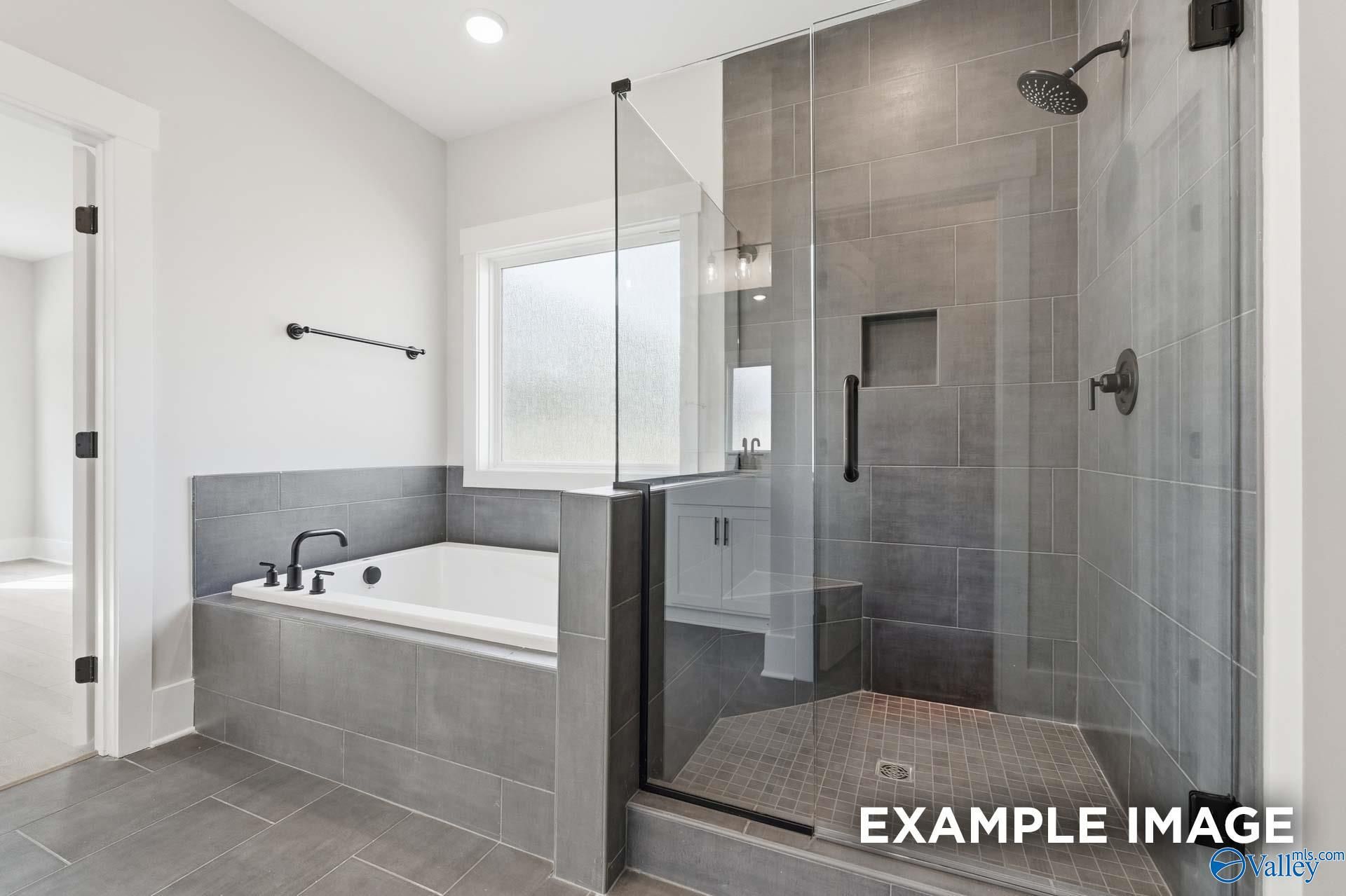 Modern primary bathroom with walk-in tile shower and soaking tub in The Rockford floor plan at Briercreek, Meridianville.