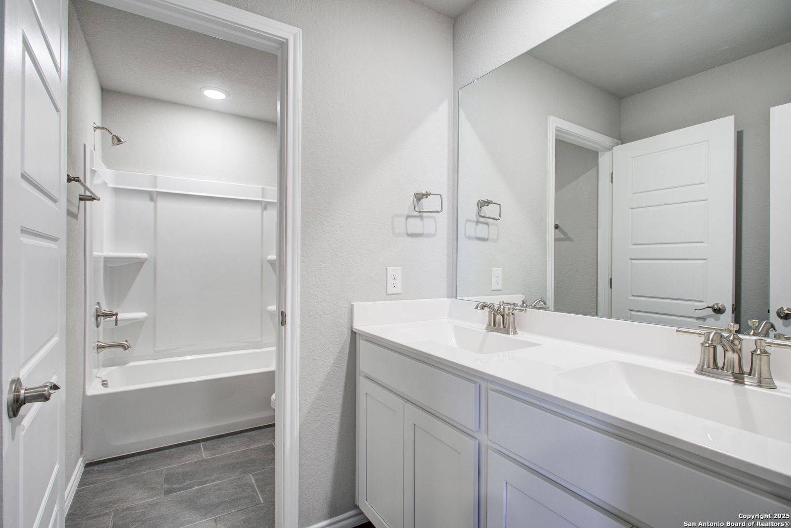 Modern bathroom with double vanity sinks, freestanding tub, and shower in Davidson Homes The Douglas G, San Antonio