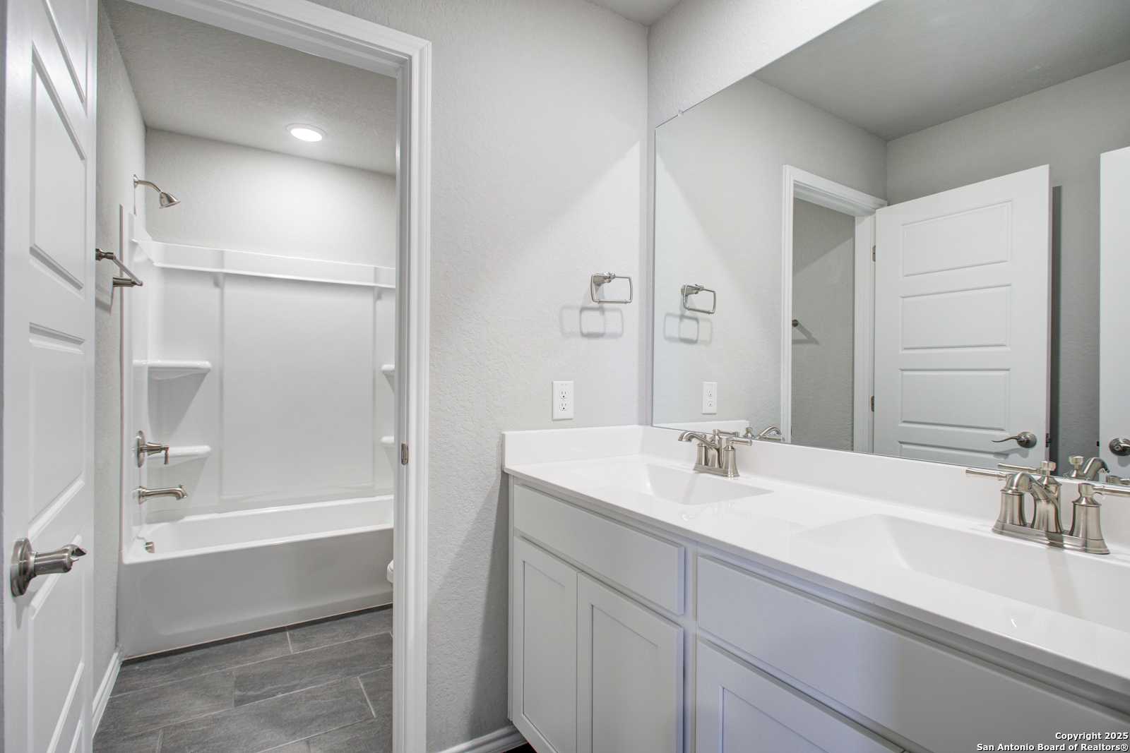 Modern bathroom with double vanity sinks, freestanding tub, and shower in Davidson Homes The Douglas G, San Antonio
