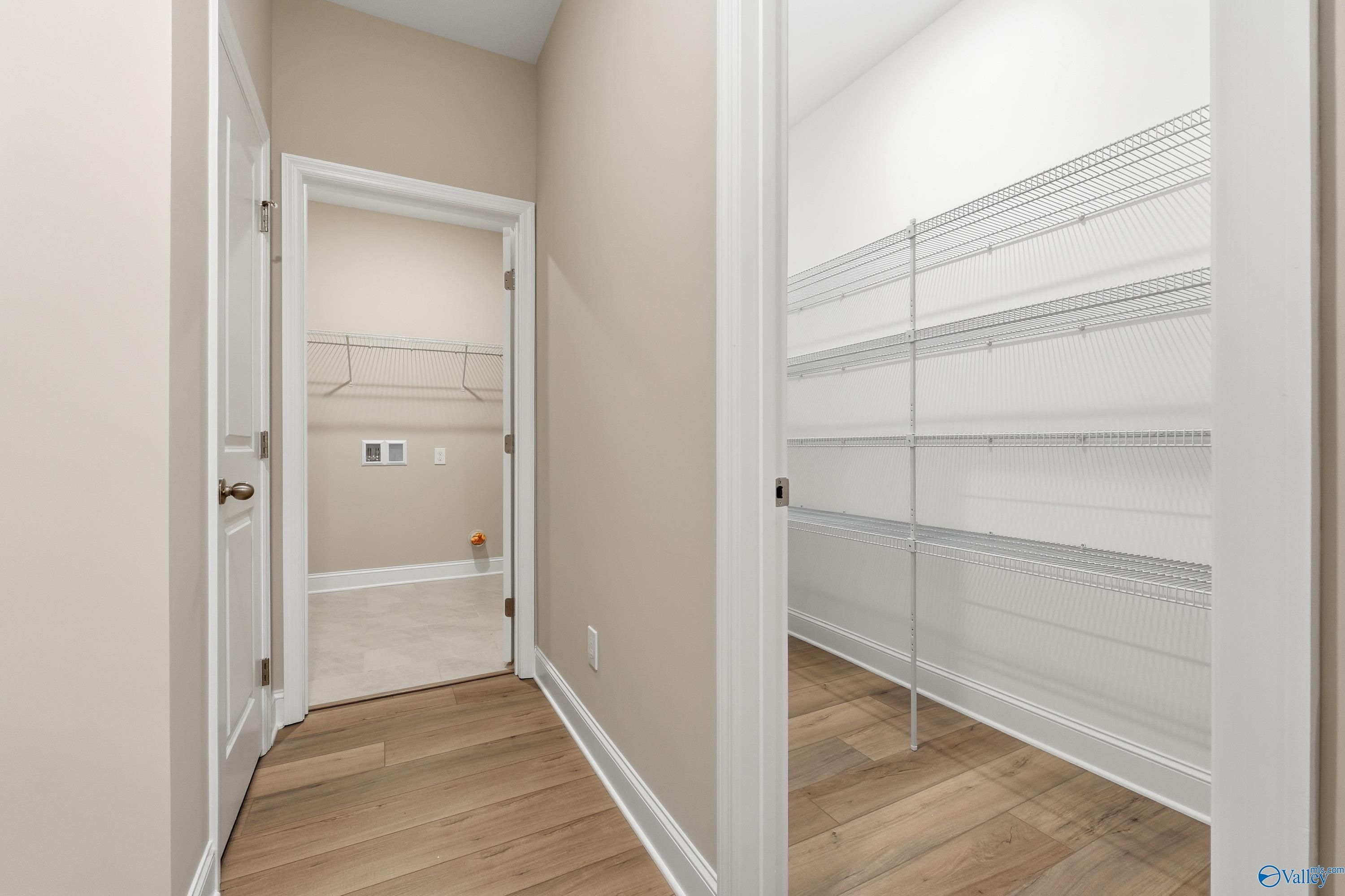 Laundry room with washer/dryer hookups, built-in shelves and adjacent walk-in pantry in Davidson Homes The Lanier, Meridianville AL