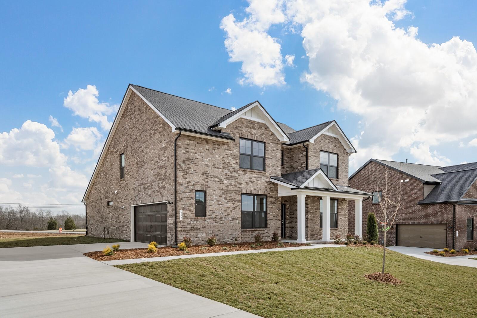 Two-story brick Ridgeport D home with 2-car garage, front porch, and landscaped yard in Benders Cove, Mt. Juliet, Tennessee