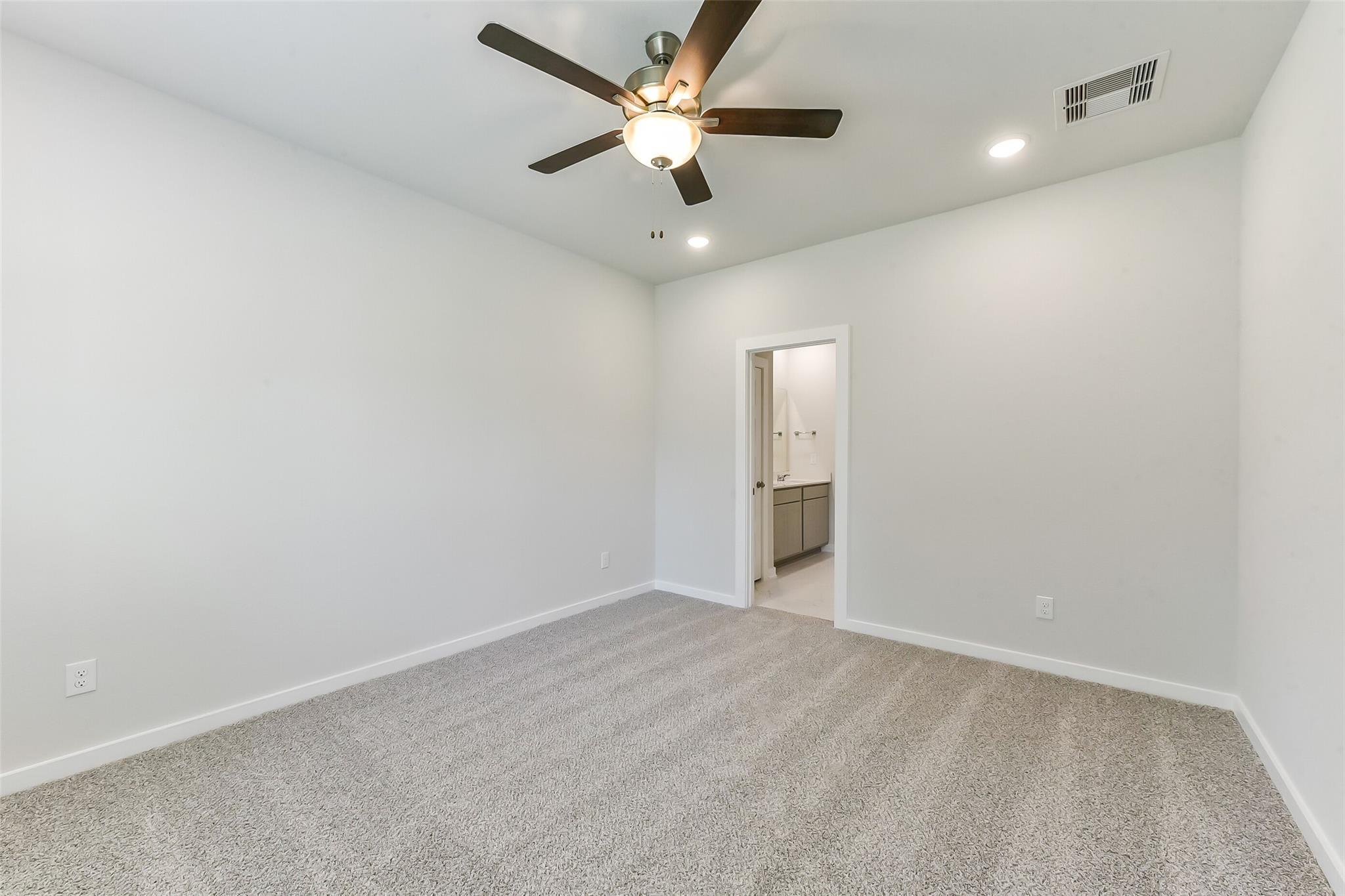 Bright secondary bedroom with ceiling fan, recessed lights, and en-suite bath in Davidson Homes Brazos E, Magnolia, TX