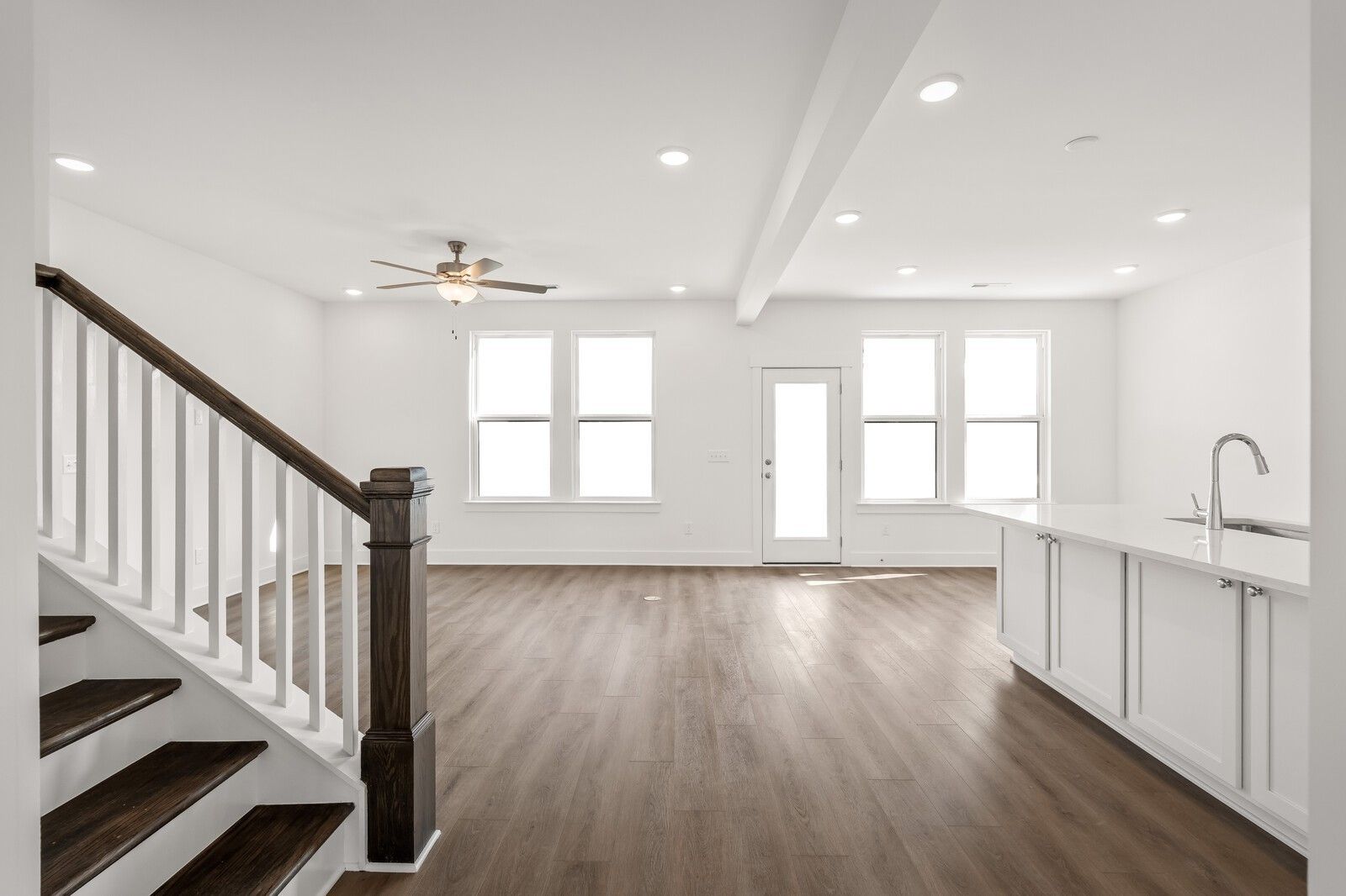 Open-concept living area with wood floors and staircase in The Willow D floor plan at Benders Cove, Mt. Juliet, Tennessee.