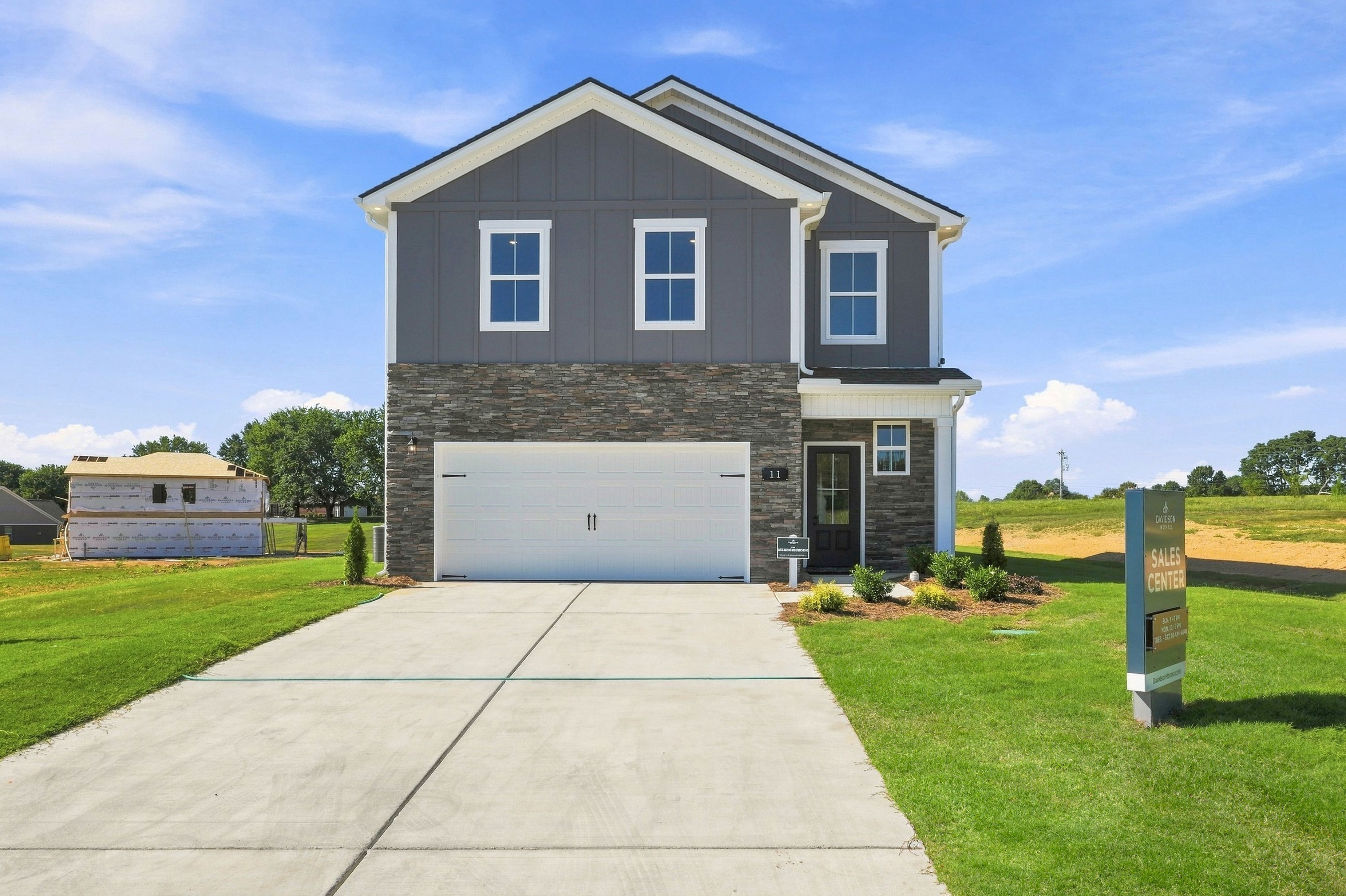 Two-story gray and stone new construction home with two-car garage at Bailey Park by Davidson Homes in Fayetteville, TN