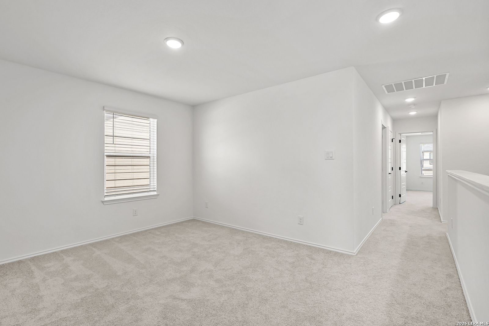 Bright, carpeted bedroom with recessed lighting in The Gillian C floor plan at Meadows at Oak Creek, San Antonio, Texas.