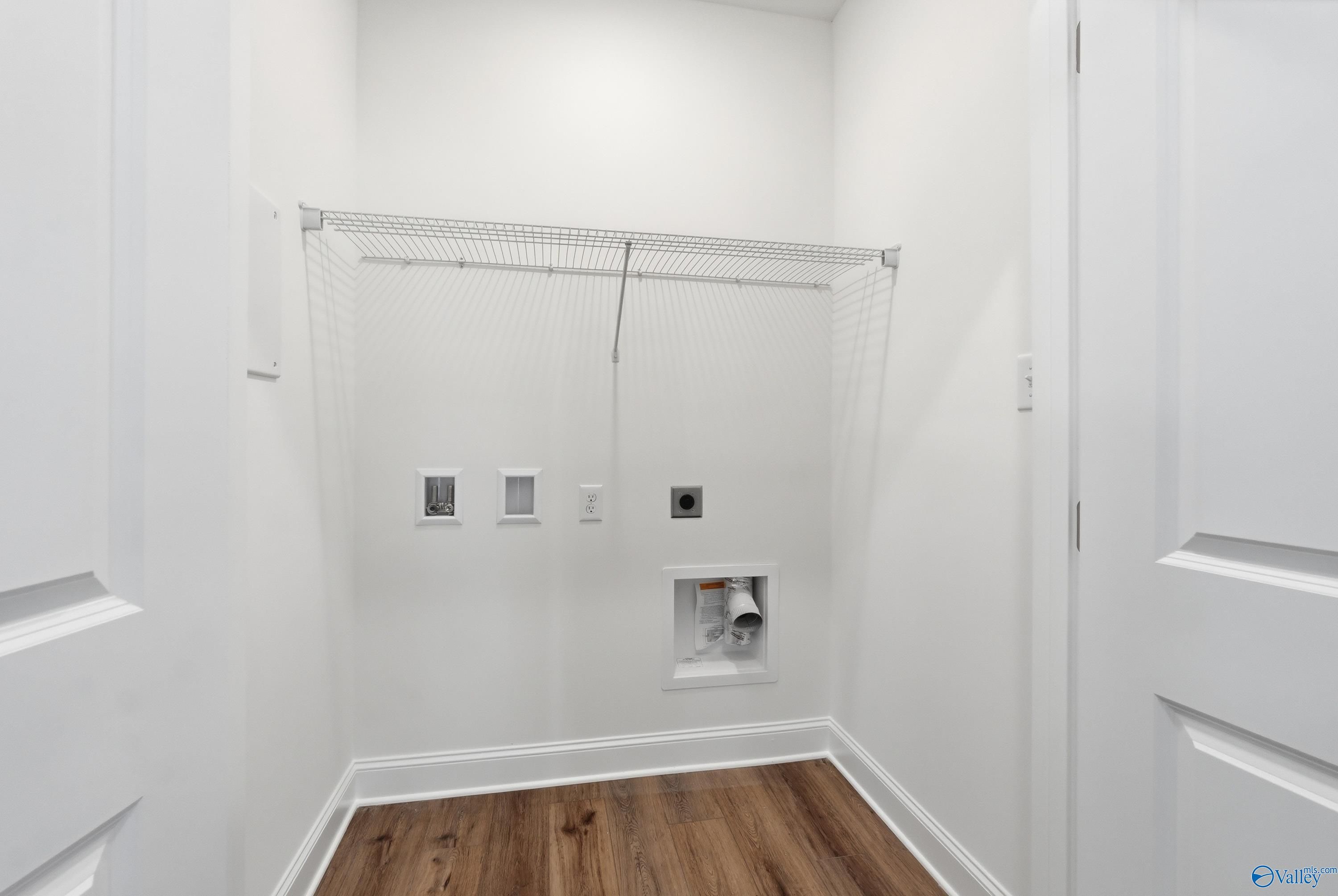 Bright laundry room with wire shelving, washer-dryer hookups and hardwood floors in Davidson Homes The Cumberland D, Decatur AL