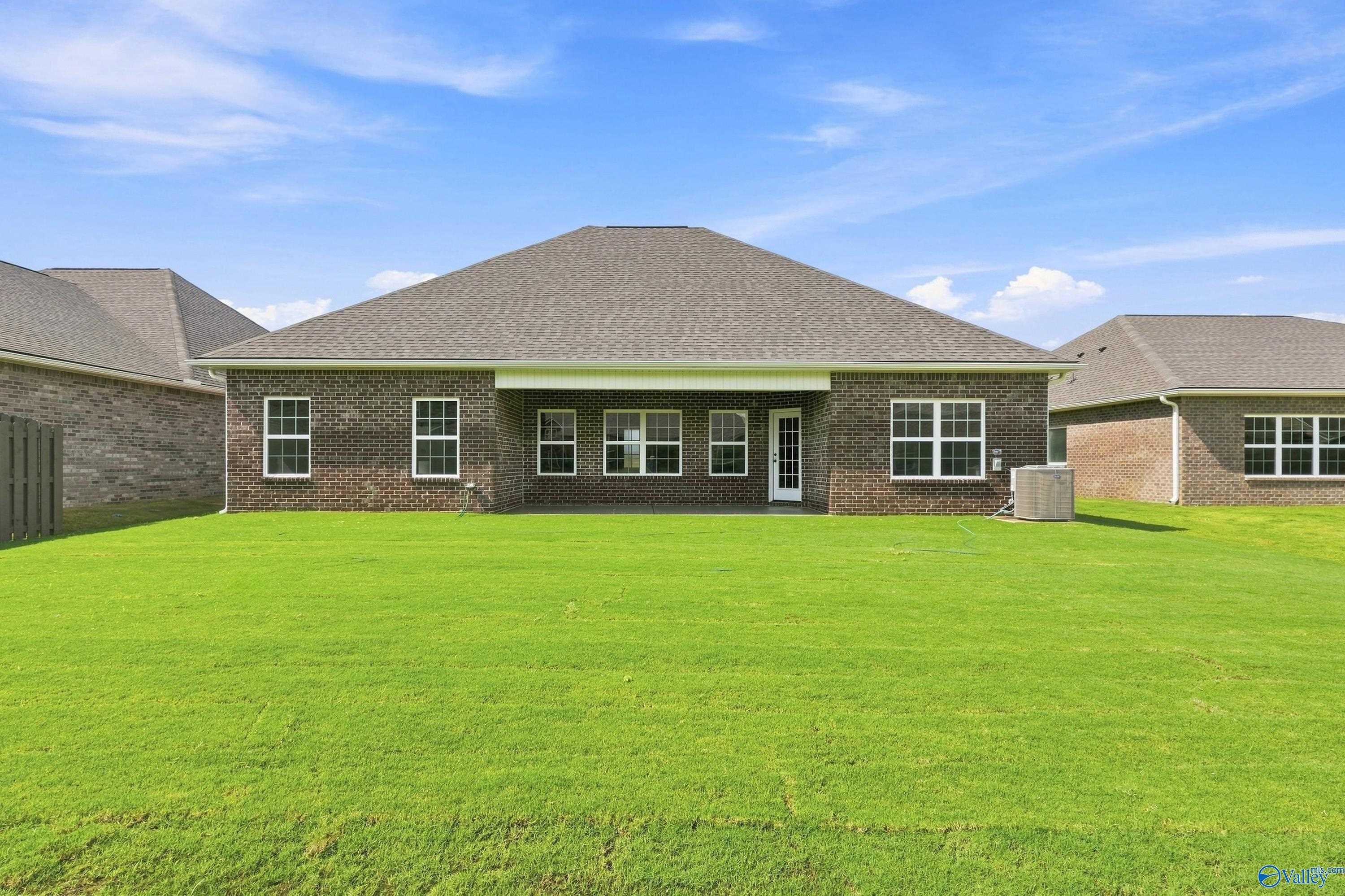 Spacious backyard and brick exterior of The Rockford B floor plan by Davidson Homes in Kendall Downs, Toney, Alabama.