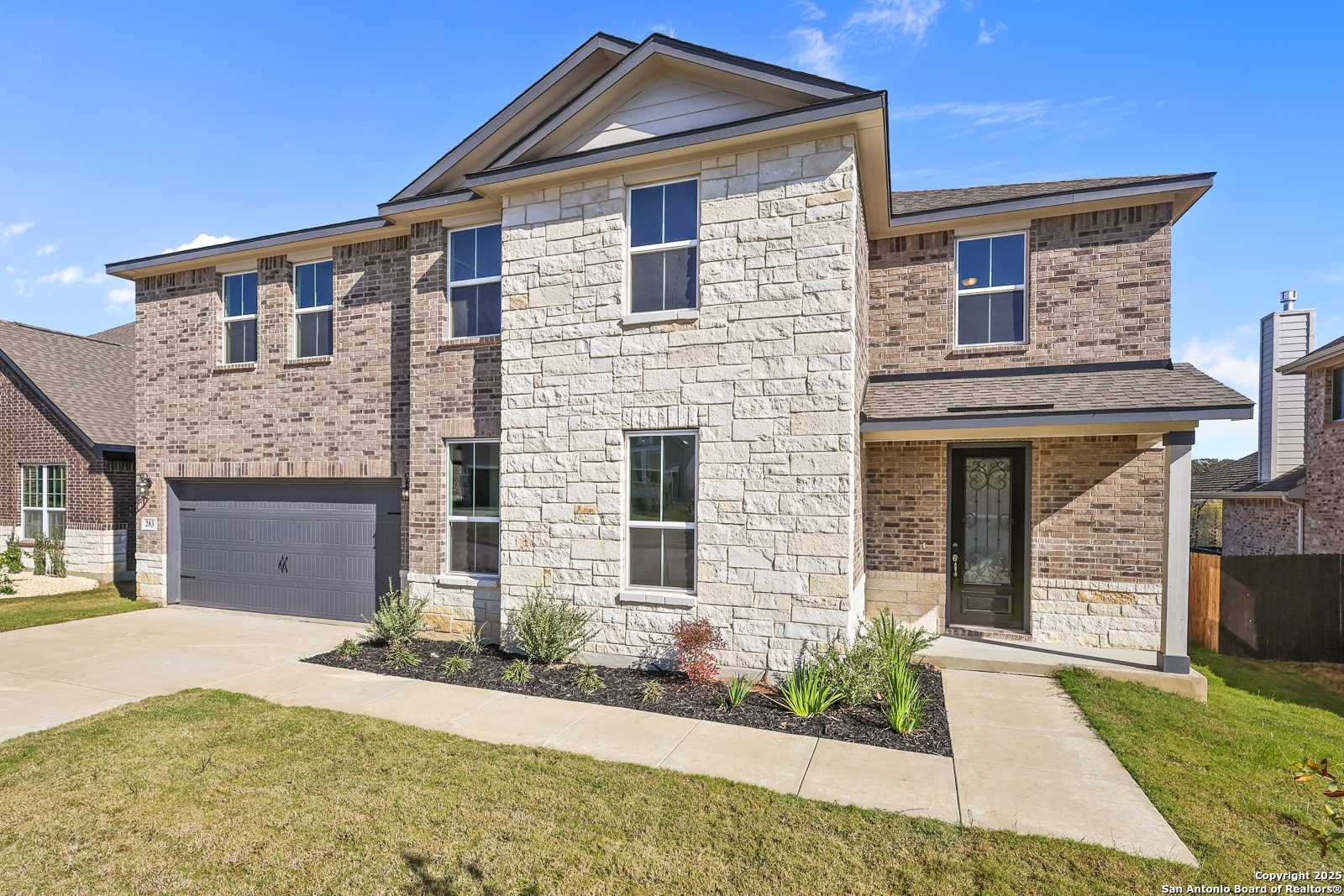 Two-story 5-bedroom Davidson Homes Jennings G with stone-brick facade, 2-car garage, driveway in The Reserve at Potranco Oaks, Castroville, TX