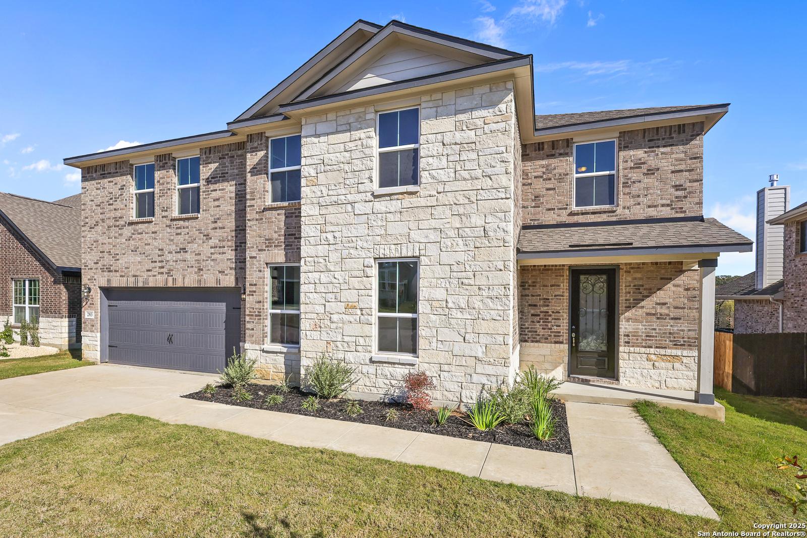 Two-story 5-bedroom Davidson Homes Jennings G with stone-brick facade, 2-car garage, driveway in The Reserve at Potranco Oaks, Castroville, TX