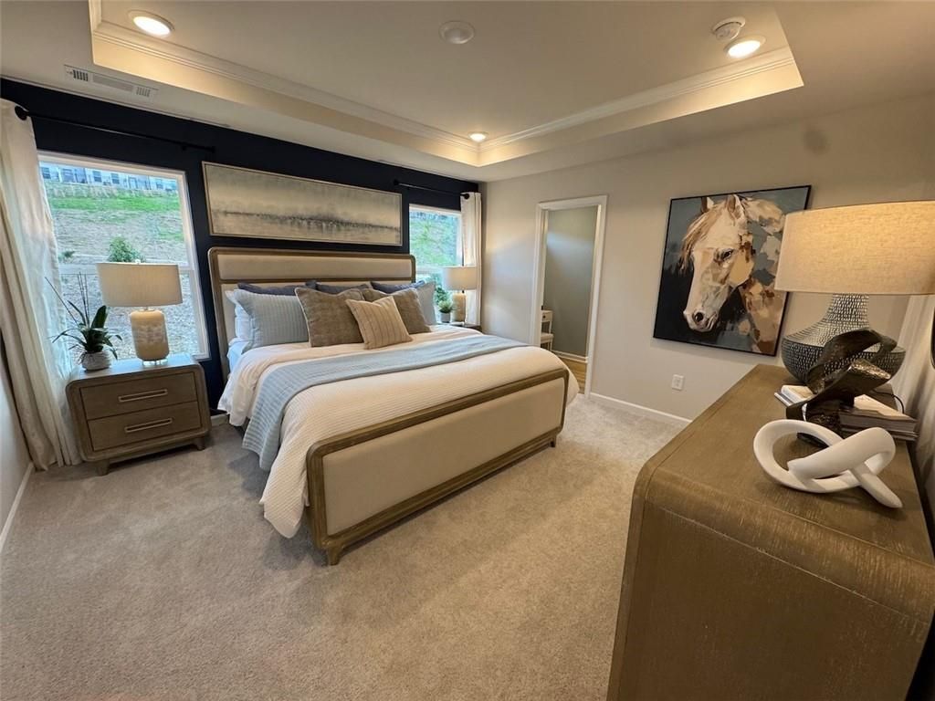 Elegant master bedroom with tray ceiling, upholstered king bed, navy wall, and horse artwork in Davidson Homes The Hartwell A, Canton GA