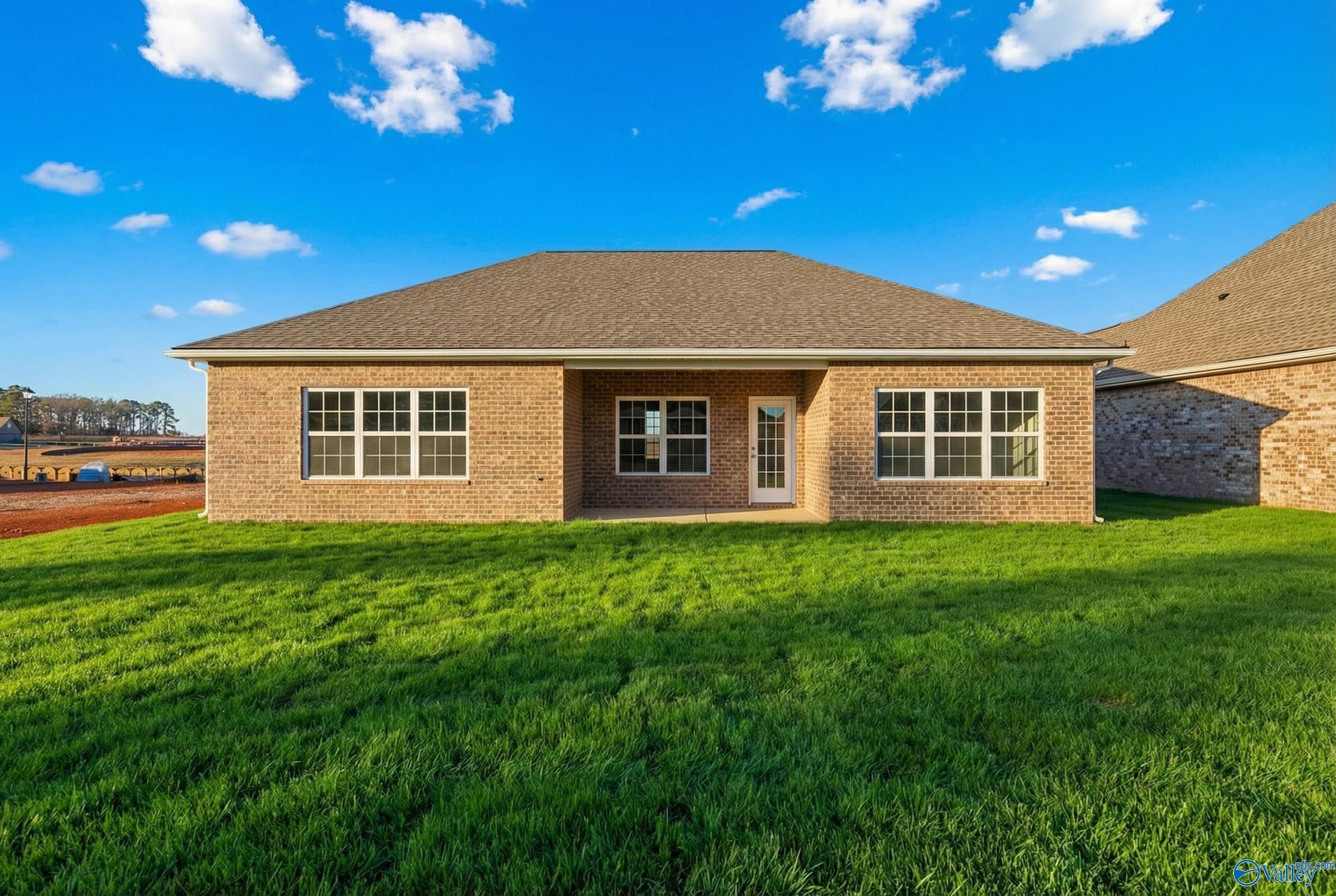 Single-story brick ranch home with hip roof, double windows, and lush green lawn in Kendall Downs, Toney, Alabama