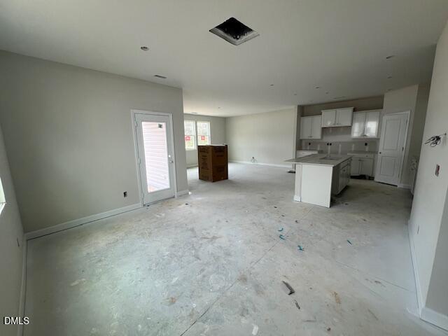 Open-concept kitchen with white shaker cabinets, central island, and French doors in new 4-bedroom Preston A home, Lillington, NC