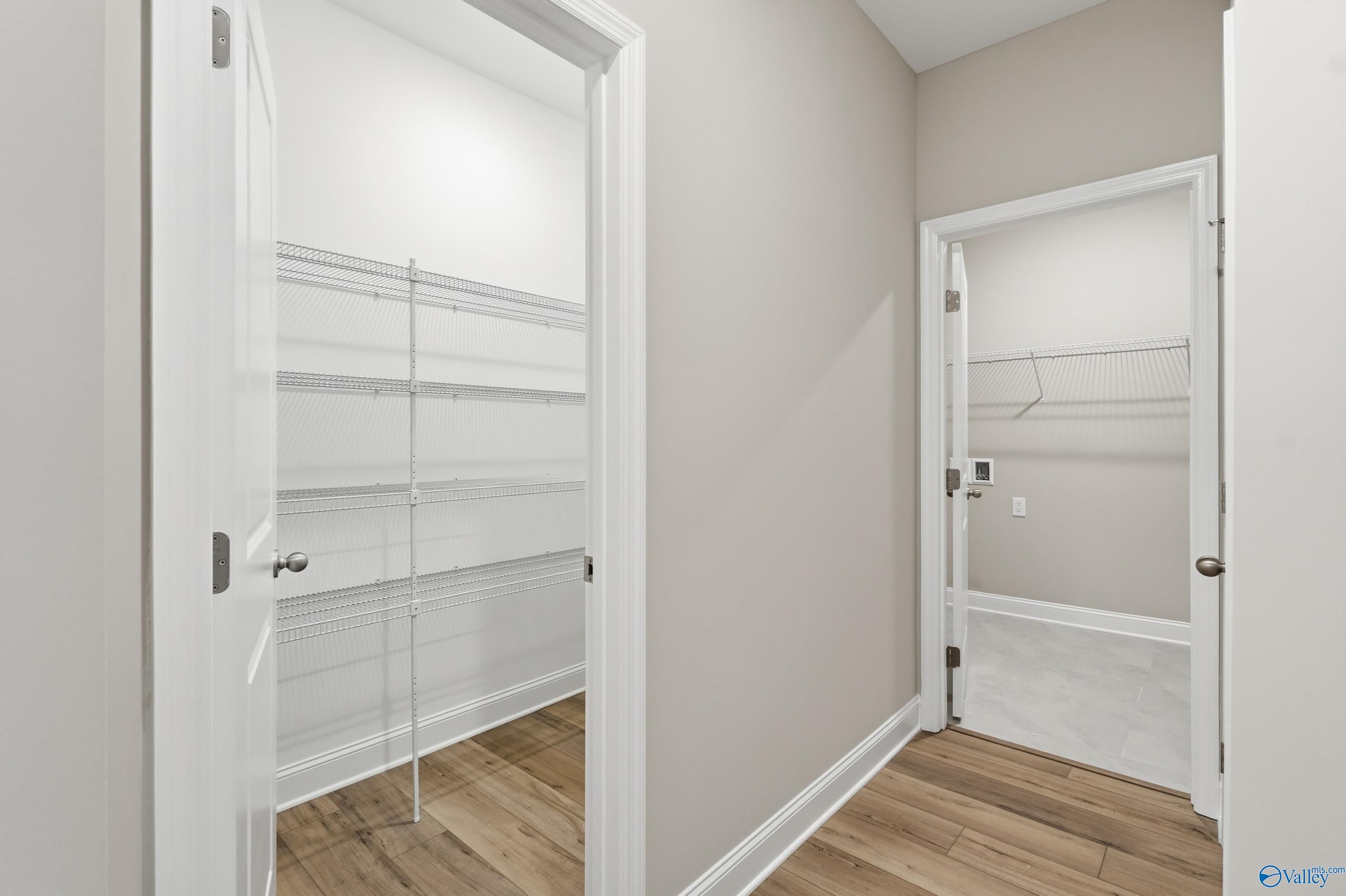 Spacious walk-in closet with white shelving and hanging rods in master suite of The Lanier 4-bedroom home by Davidson Homes in Toney, Alabama