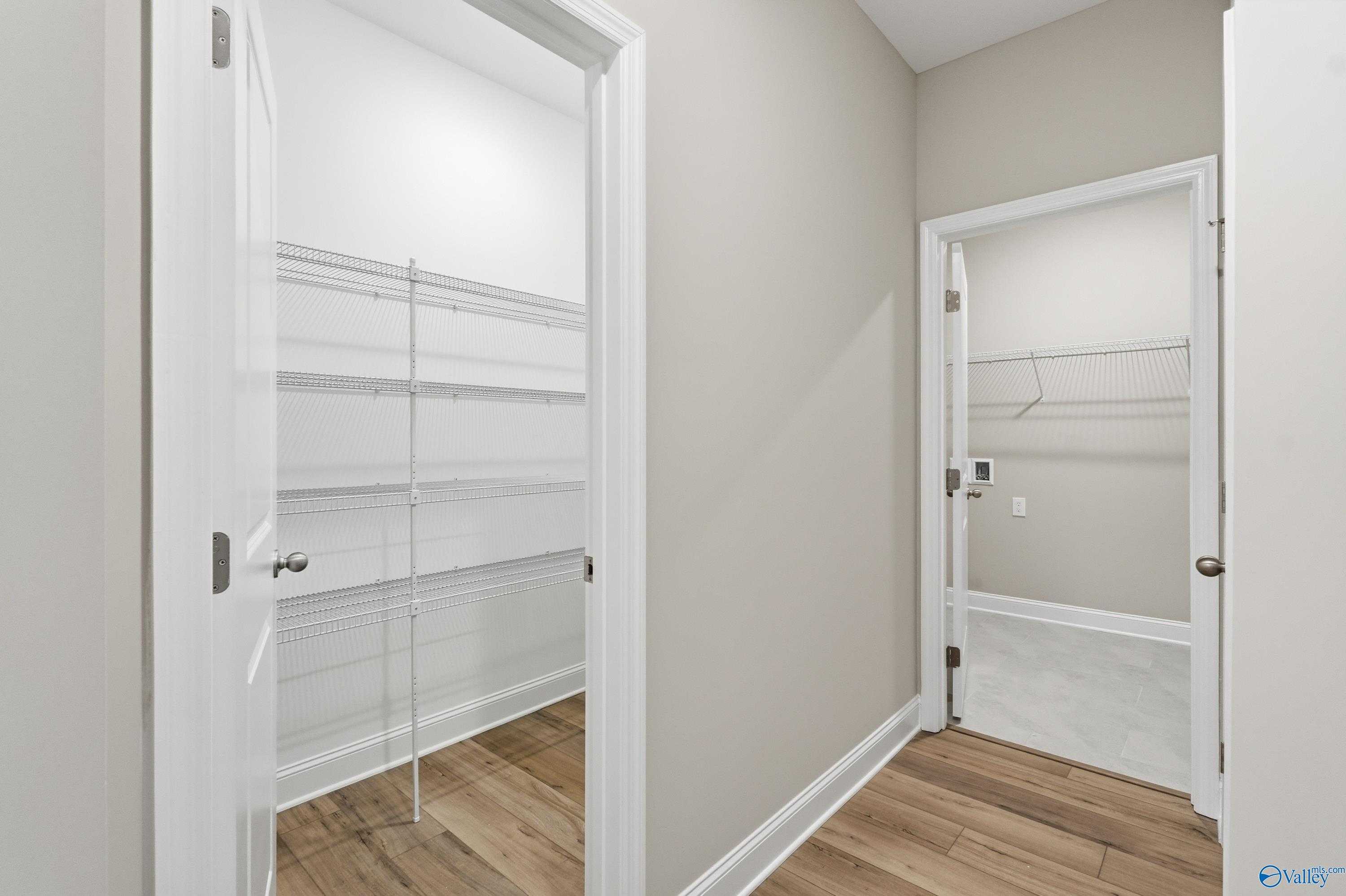 Spacious walk-in closet with white shelving and hanging rods in master suite of The Lanier 4-bedroom home by Davidson Homes in Toney, Alabama