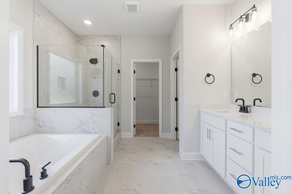 Modern master bathroom featuring glass shower, freestanding tub, and double vanity in Davidson Homes The Montgomery B, Hartselle, Alabama